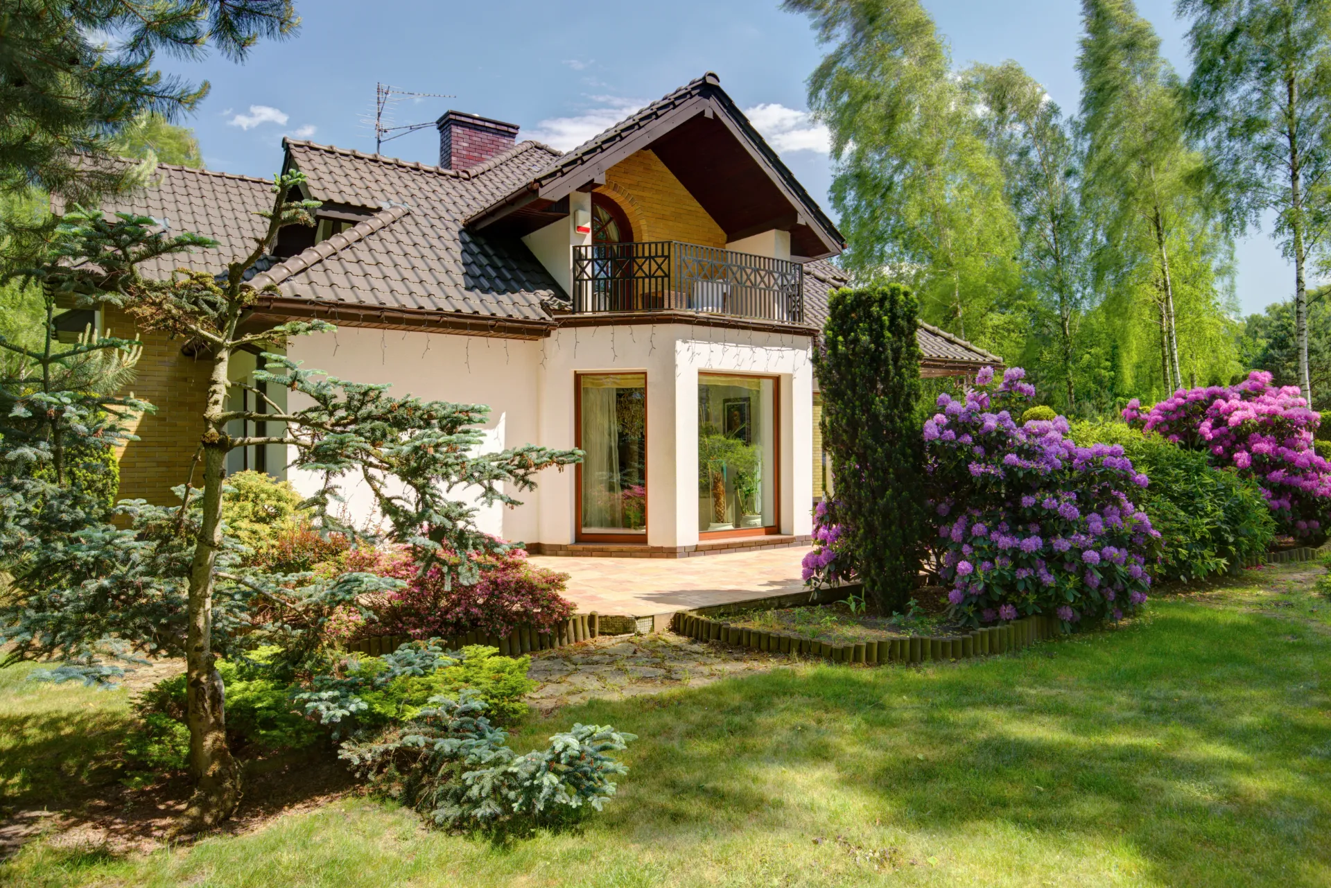 Ein Einfamilienhaus aus dem Garten heraus abgebildet.