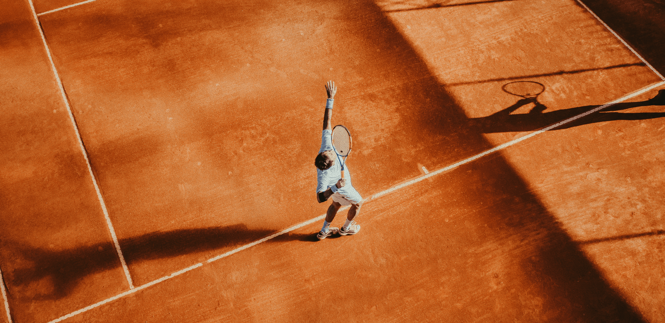 Top-view cinematic shot of tennis player competing on professional clay court