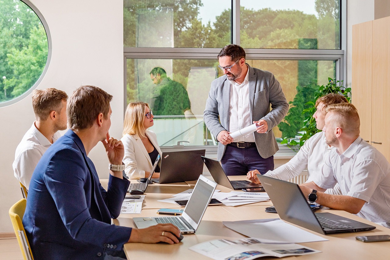 ludzie siedzący przy jednym stole w biurze.