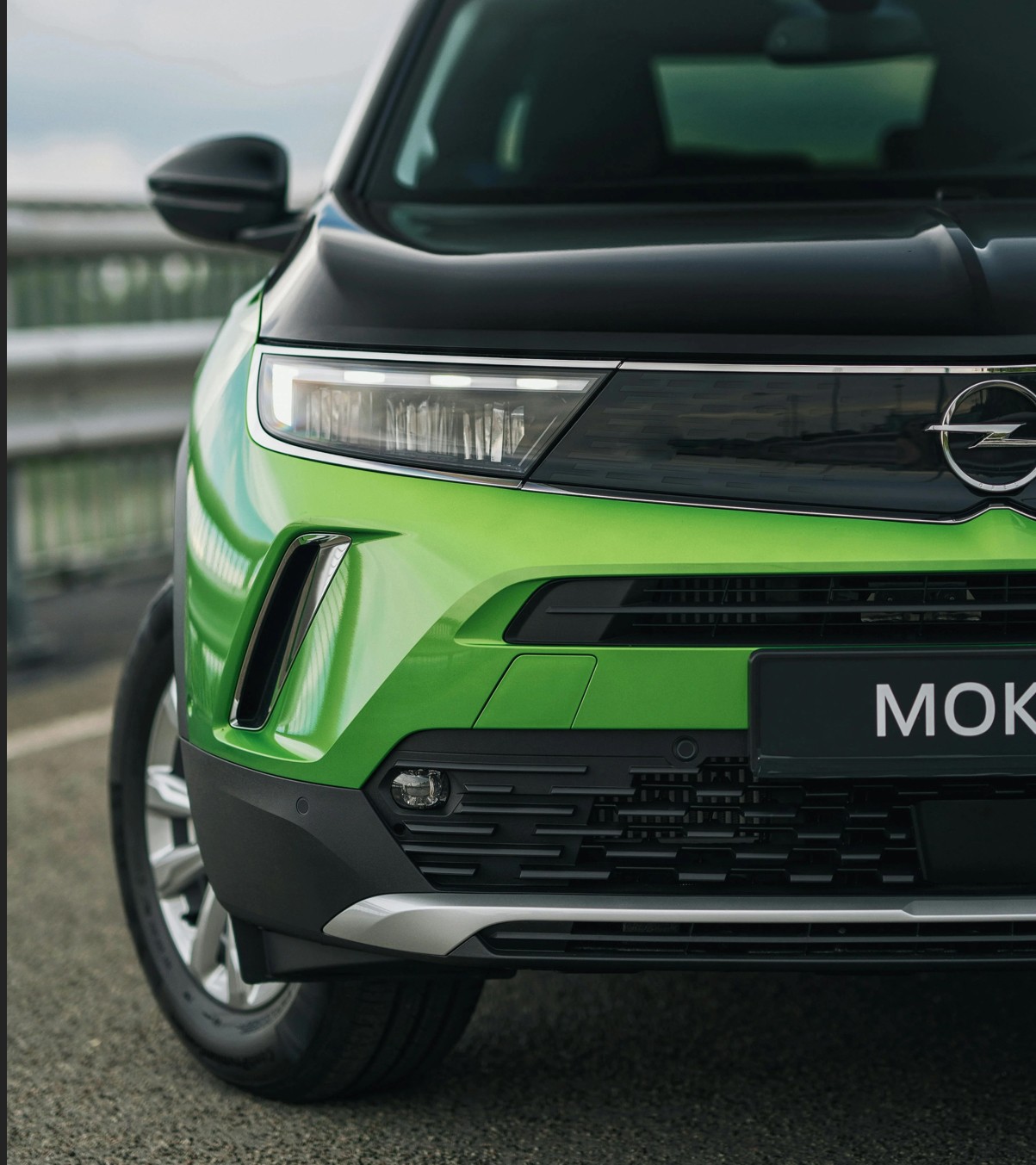 Un gros plan sur l’avant d’un Opel Mokka en finition vert vif et noir, révélant la signature Vizor, les lignes tendues et les détails modernes du SUV. L’image souligne le nouveau langage stylistique d’Opel, plus épuré et affirmé.