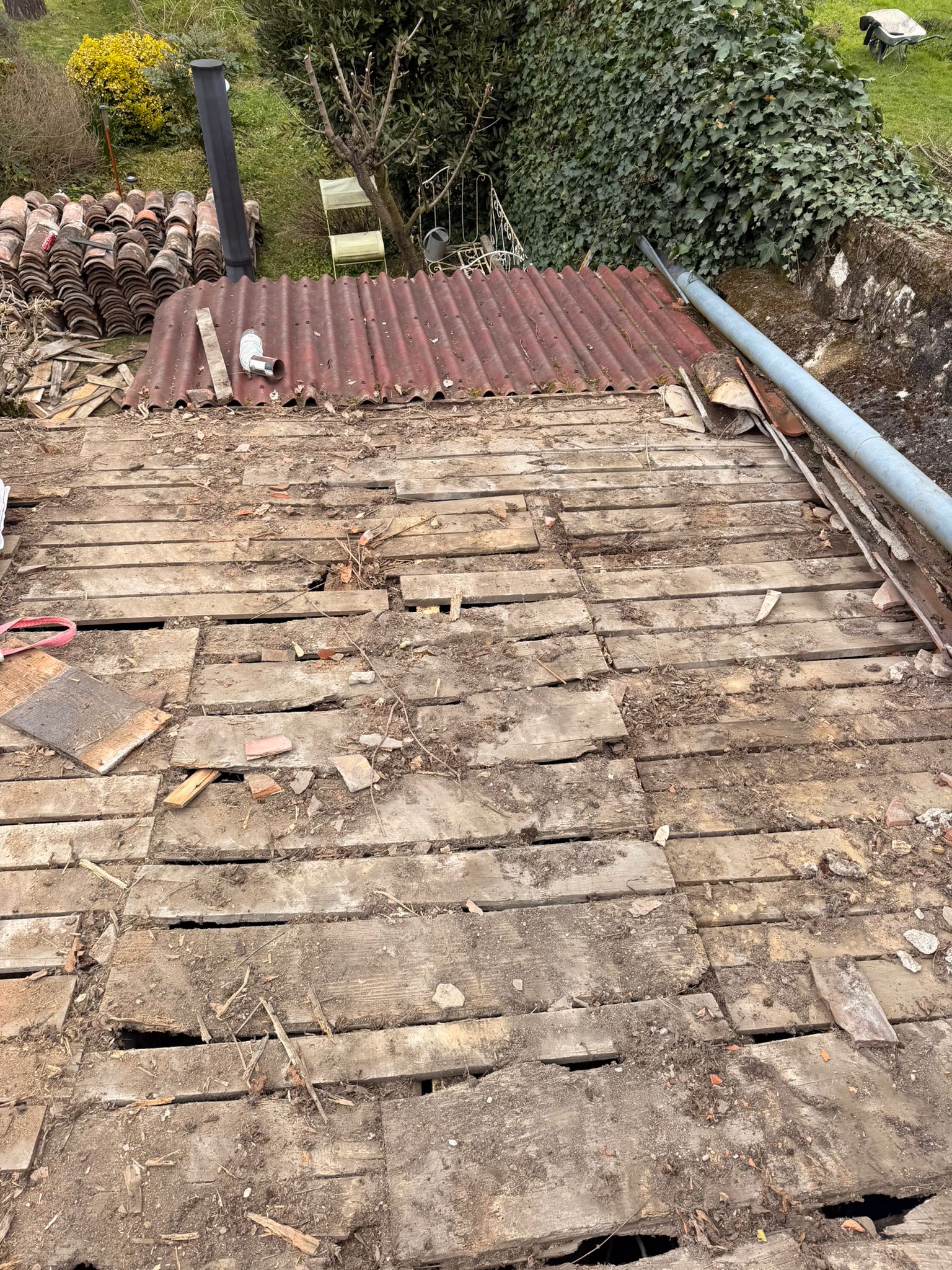 Couvreur réparant une soudure de gouttière en zinc sur une maison en pierre à Saint-Girons