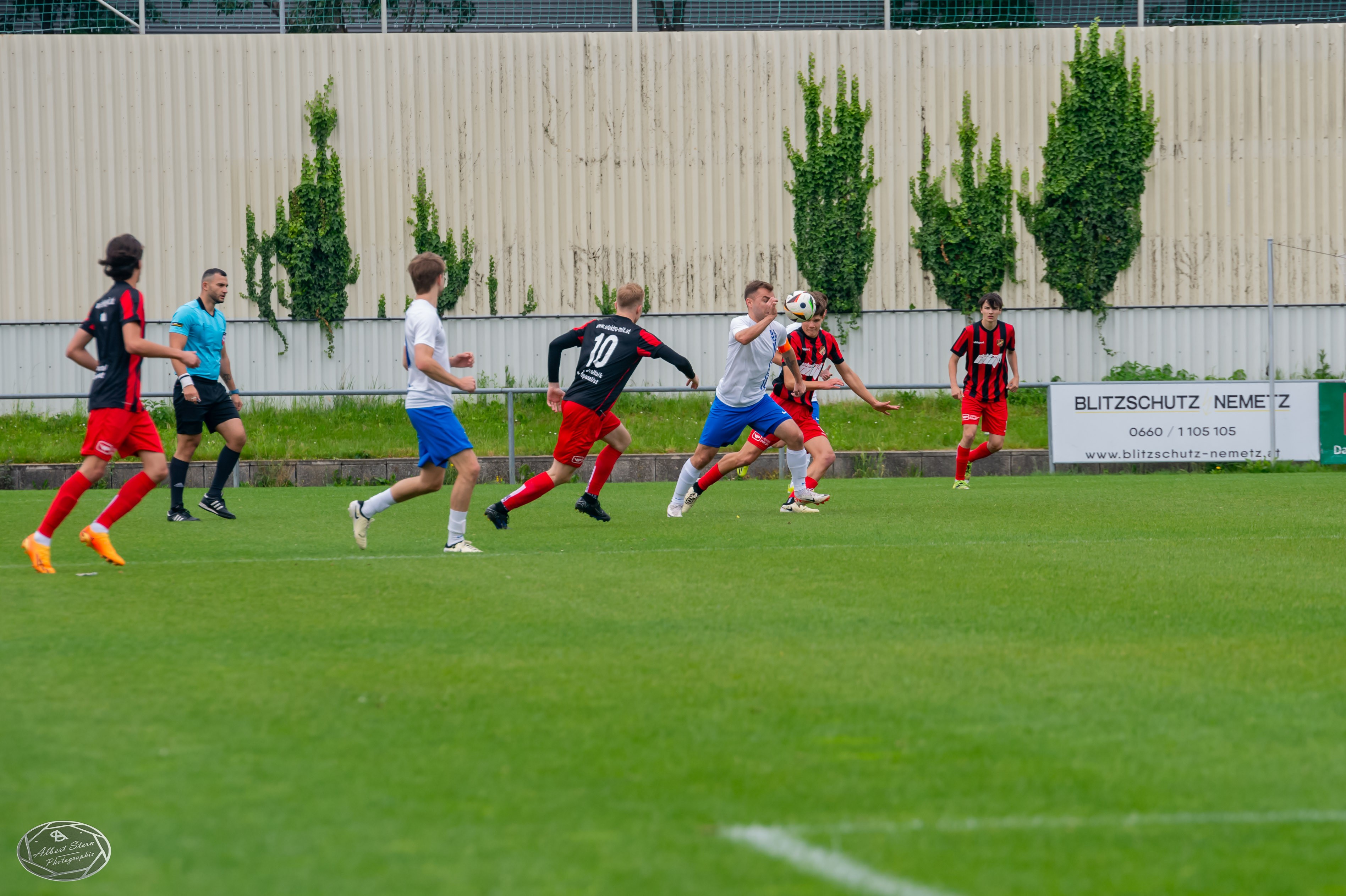 Players run after a football on the pitch
