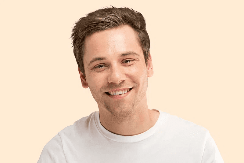 Profile portrait of a man in a white shirt against a light background