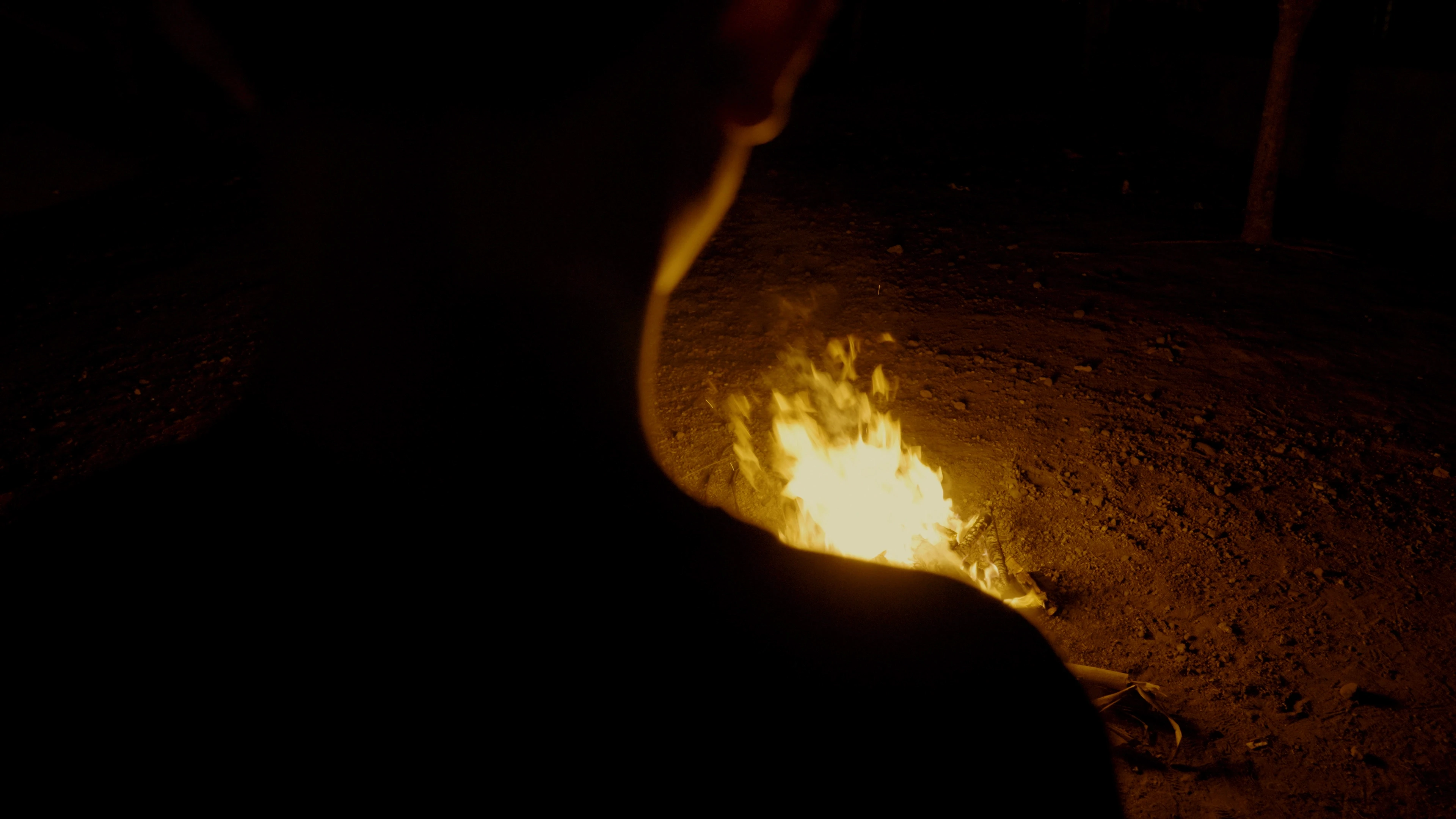 a child stares into a bonfire 