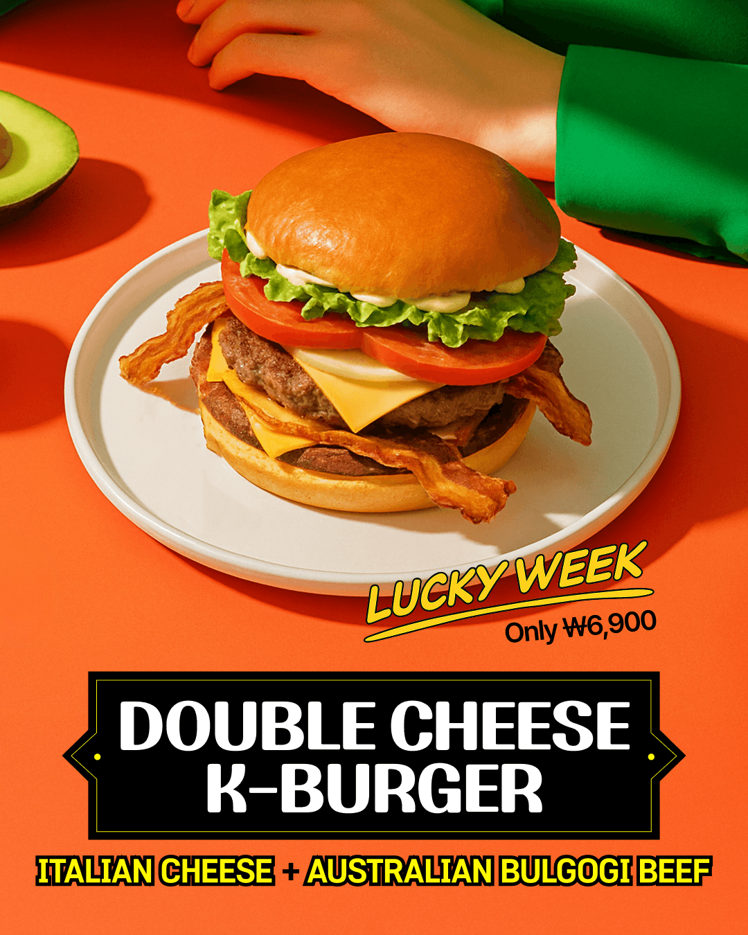 Smiling young woman with long hair standing against a dark green background, holding a finger to her chin.
