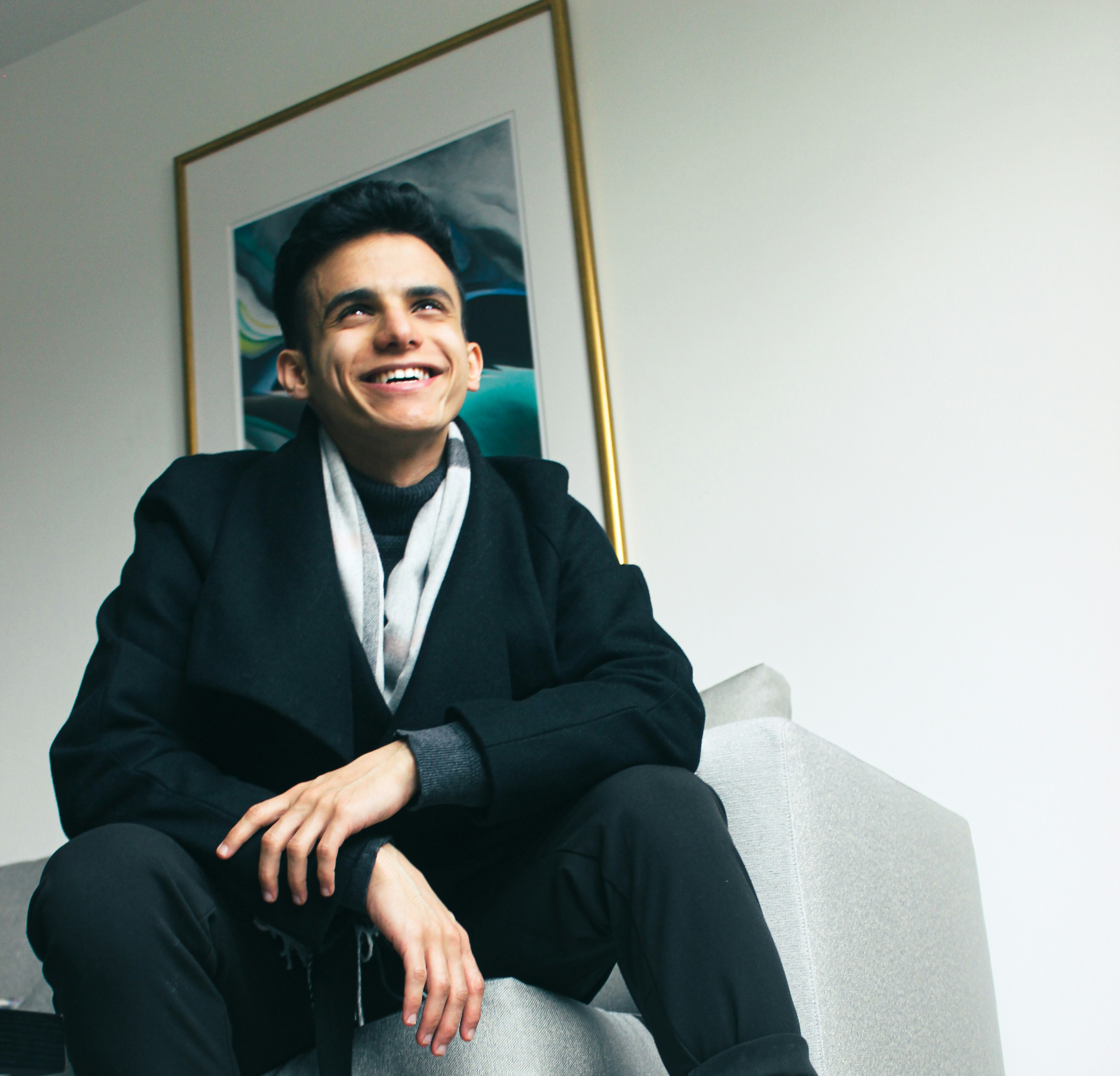 a woman kneeling on the beach with a dog