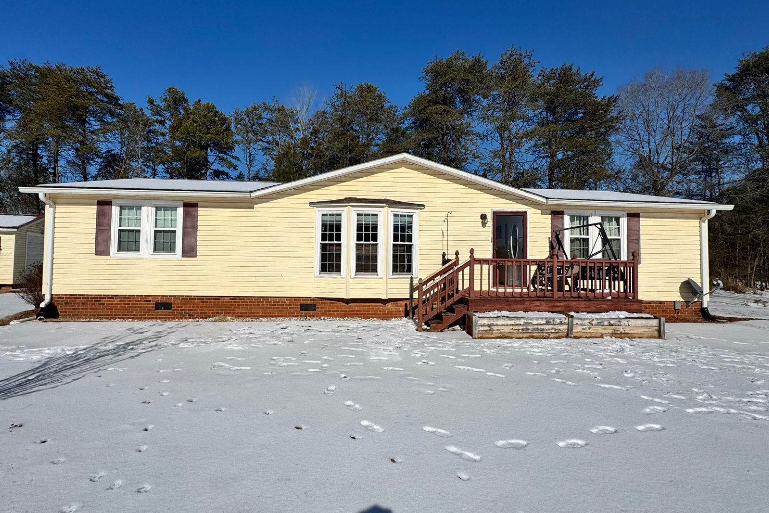 Before photo of an elevated wood front deck prior to a stamped concrete patio and covered porch renovation in Lewisville NC.