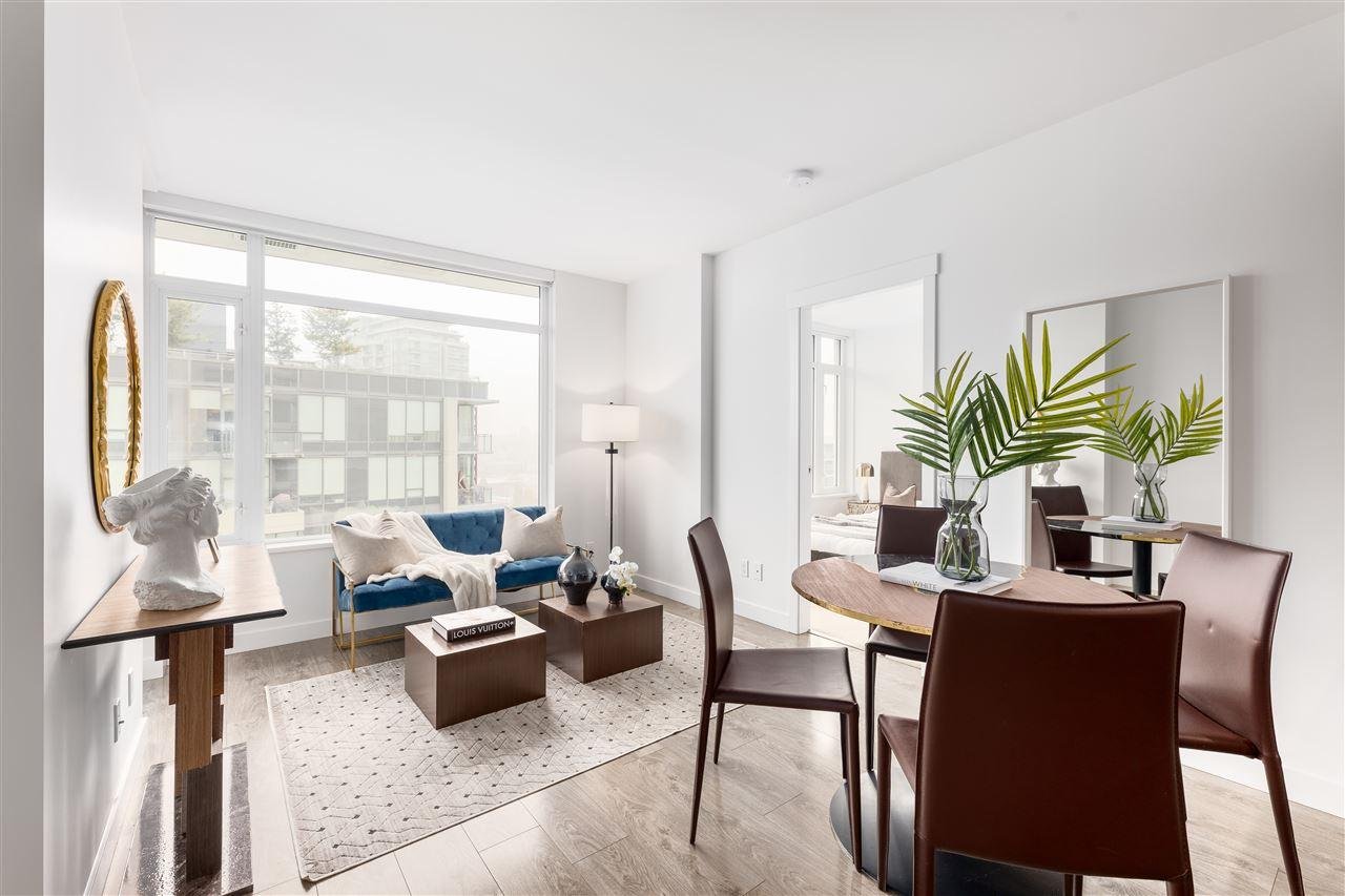 Bright, modern interior featuring a dining area with a table, chairs, and potted plants by large windows.