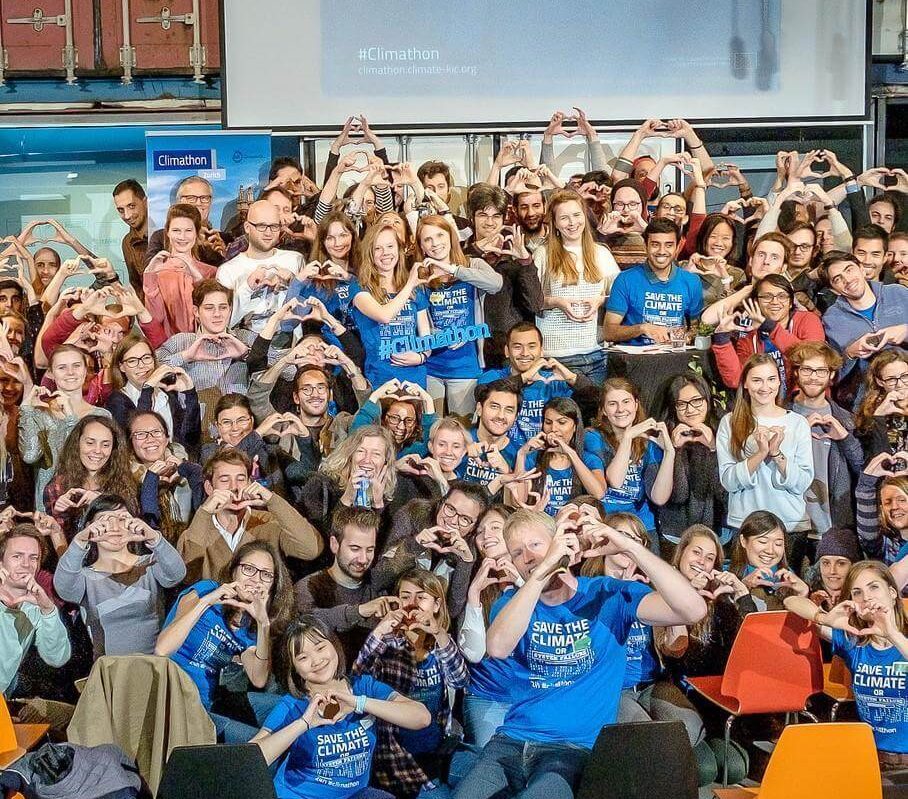 Grande grupo de jovens com camisetas Save the Climate fazendo coração com as mãos no Climathon