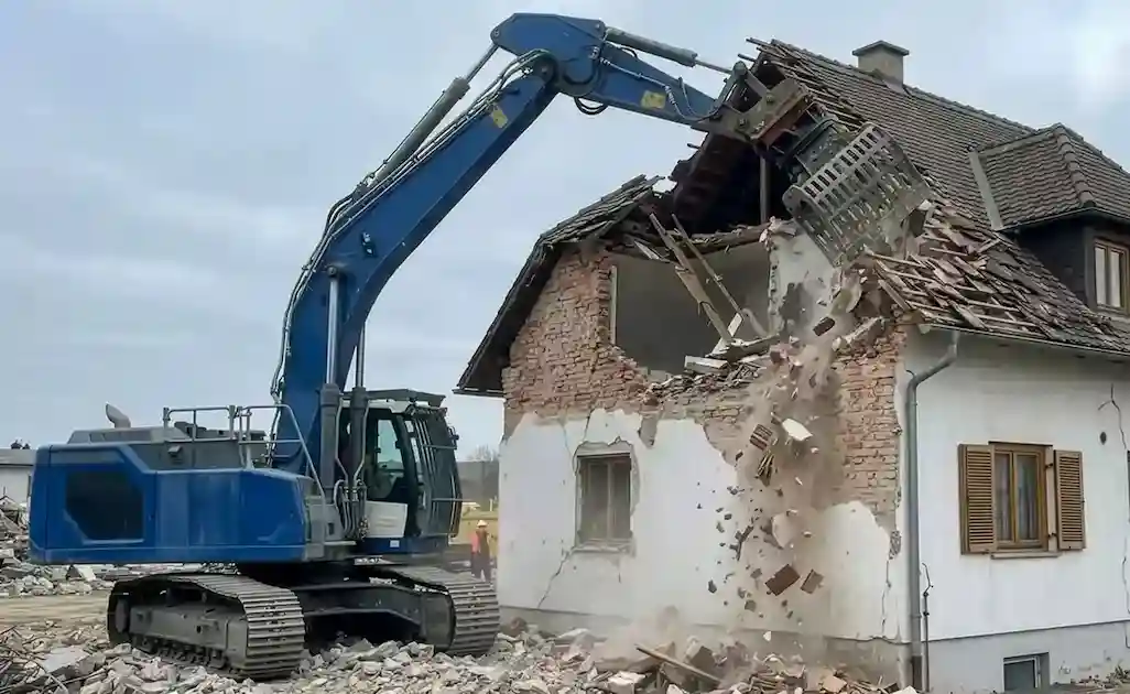 Bagger bei Abbrucharbeiten im Außenbereich beim Rückbau eines Wohngebäudes