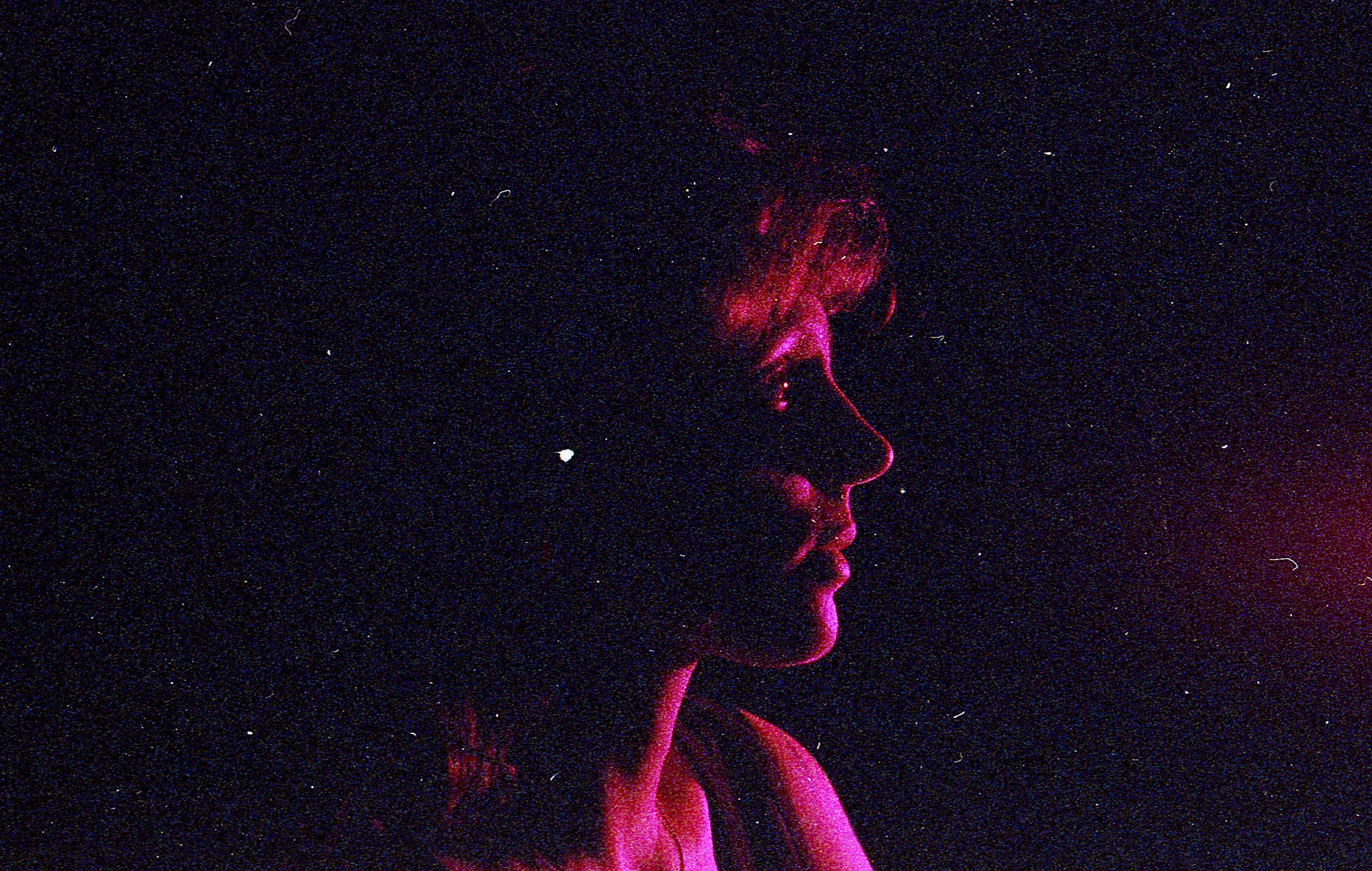 Silhouette of a person's face behind a wet surface.