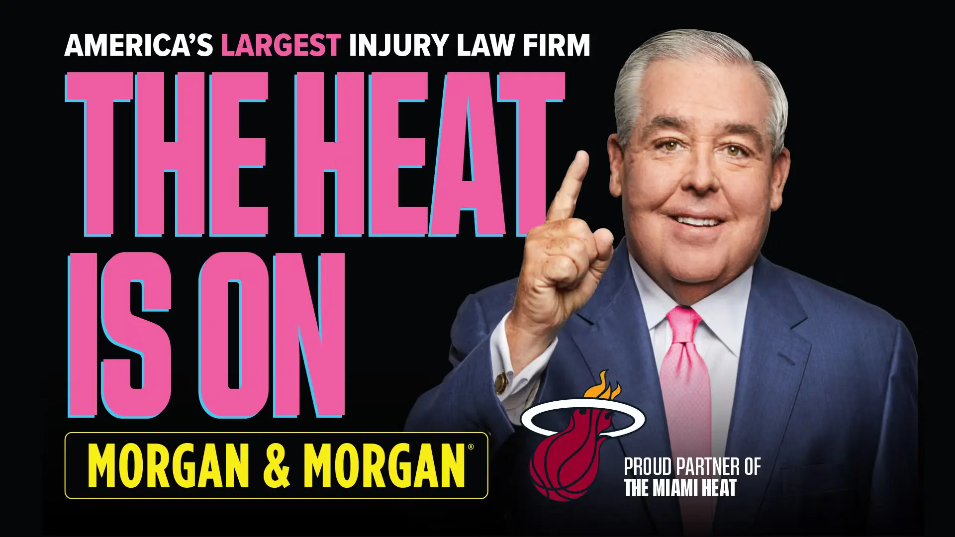Advertisement for Morgan & Morgan featuring a suited man smiling and pointing upward beside large pink text that reads “The Heat is On,” with a Miami Heat logo and tagline “Proud Partner of the Miami Heat.” Highlights the injury law firm’s sponsorship and branding.