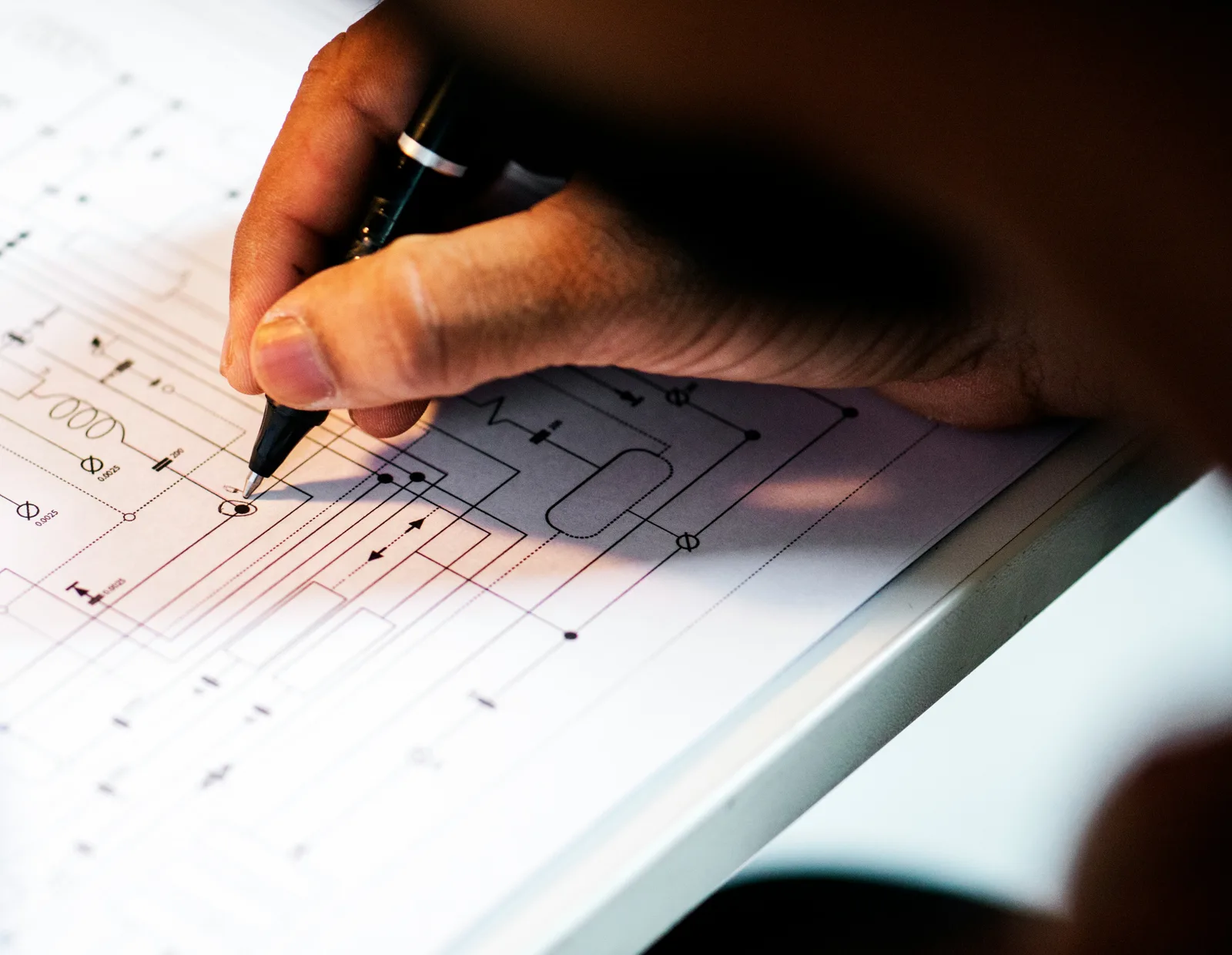 Ръка чертае електрическа схема на светлинна маса