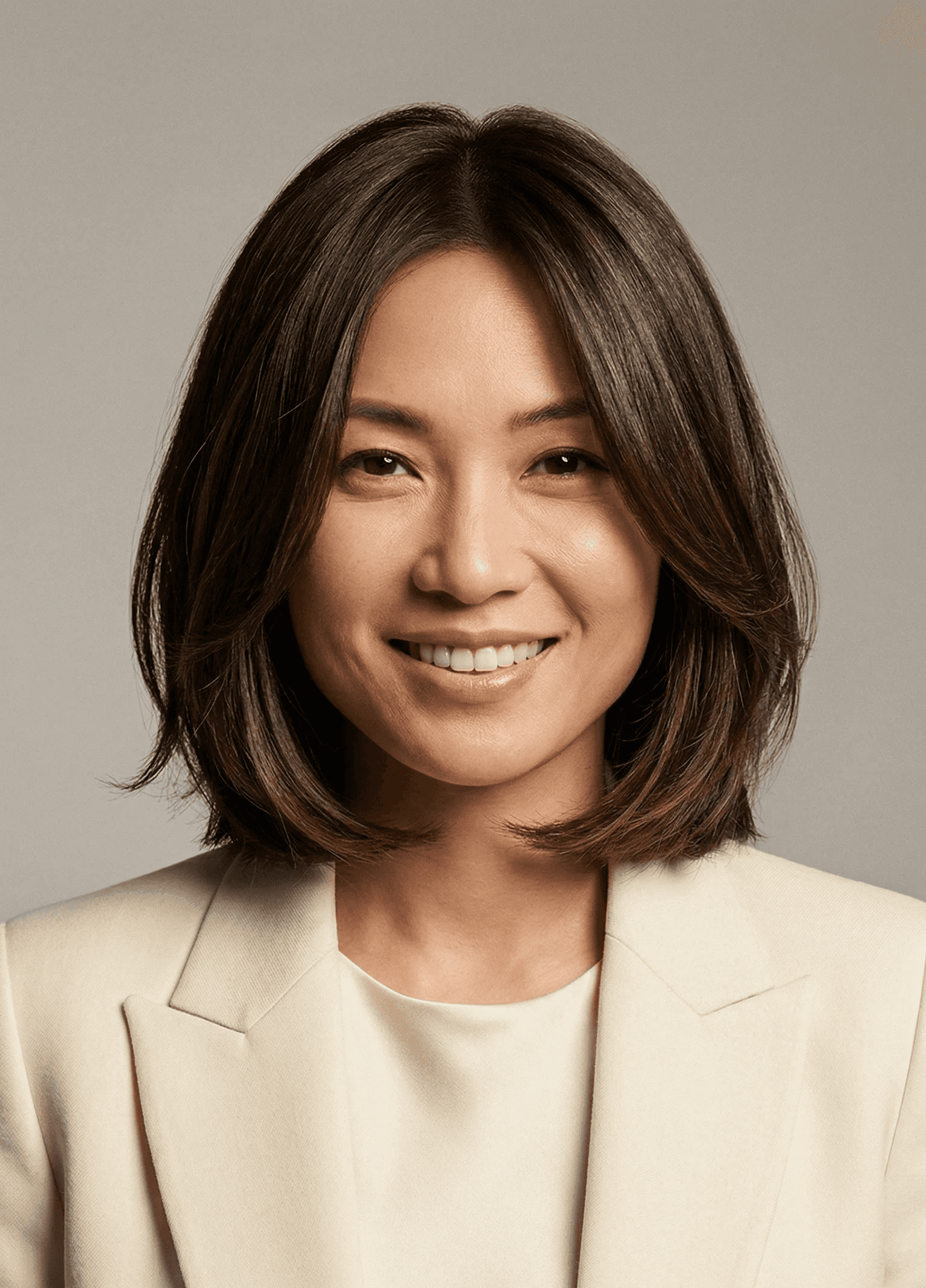 Smiling Sydney real estate agent from Reeltor in a cream blazer, looking approachable and professional.