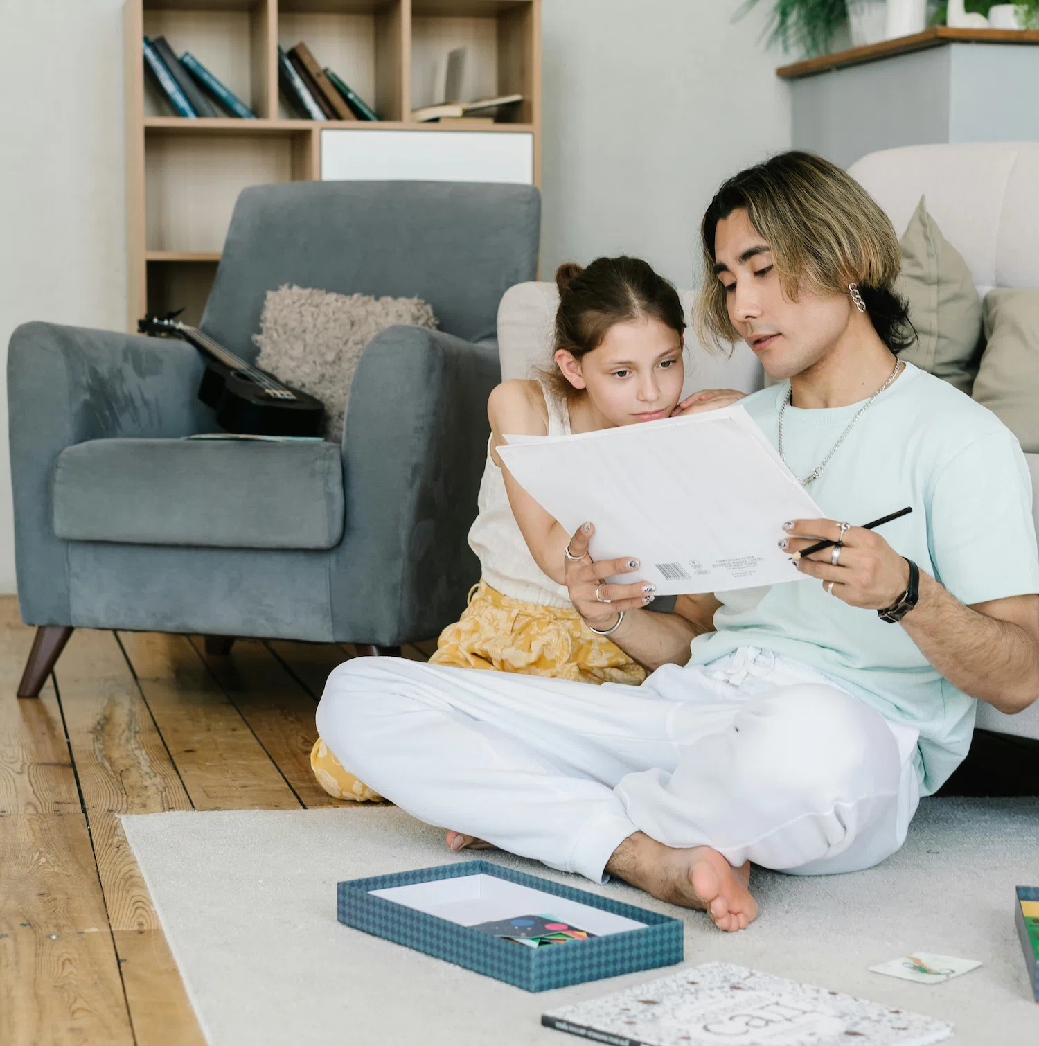 Parent and child sitting together on the floor creating art, symbolizing connection, support, and open communication in LGBTQ+ family therapy in Los Angeles.