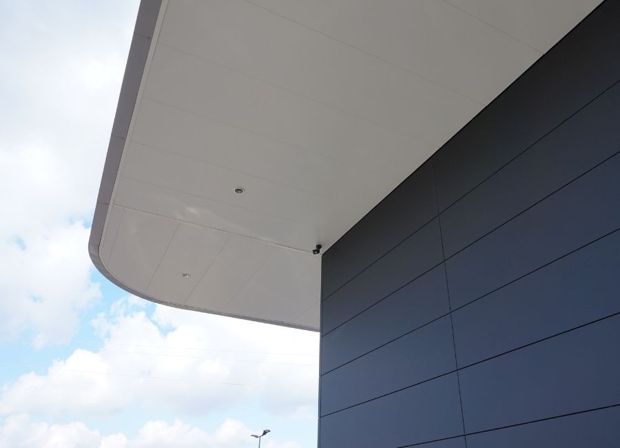 Vue en contre-plongée d’un débord de toiture avec finition lisse et épurée.