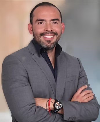 a man in a suit standing with his arms crossed