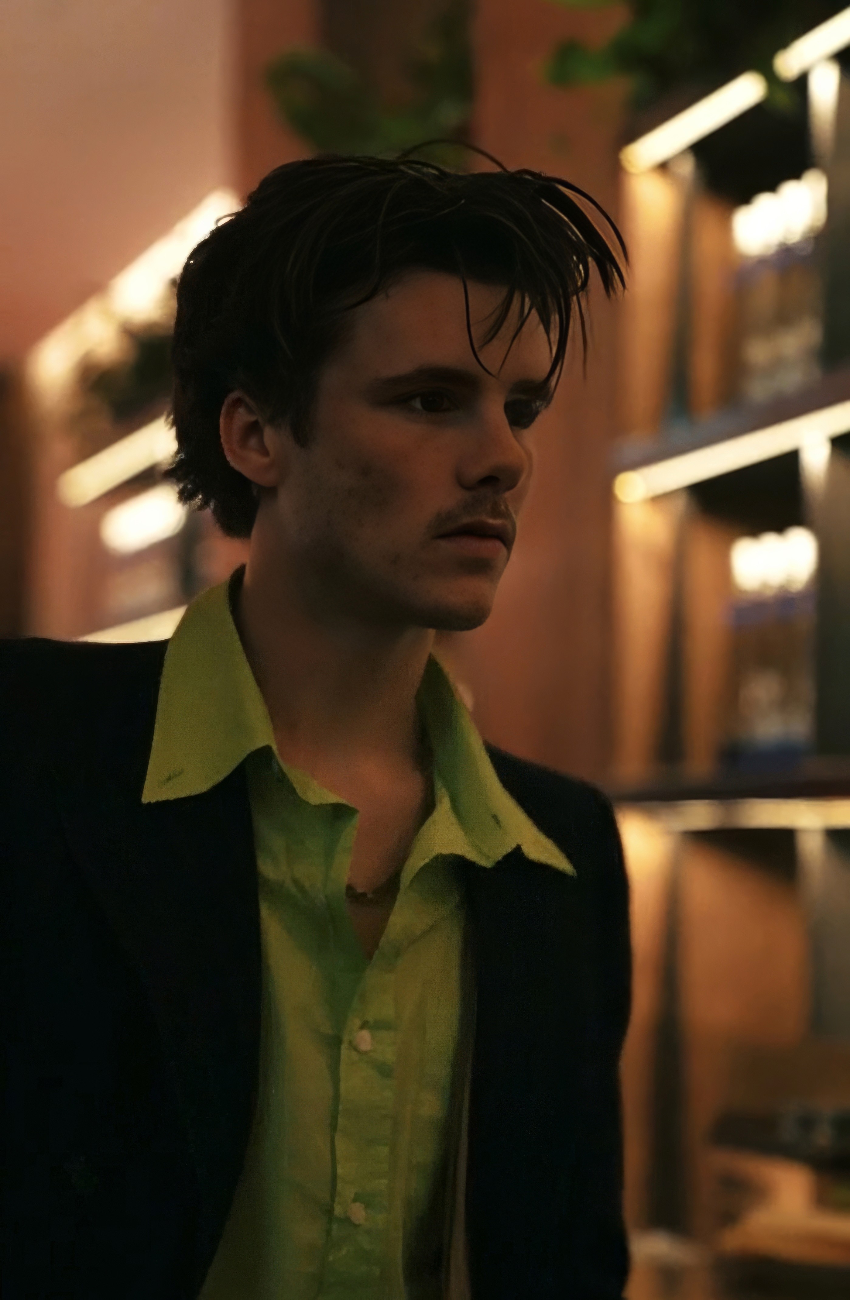 Dancer in black outfit with arms raised, arching backwards