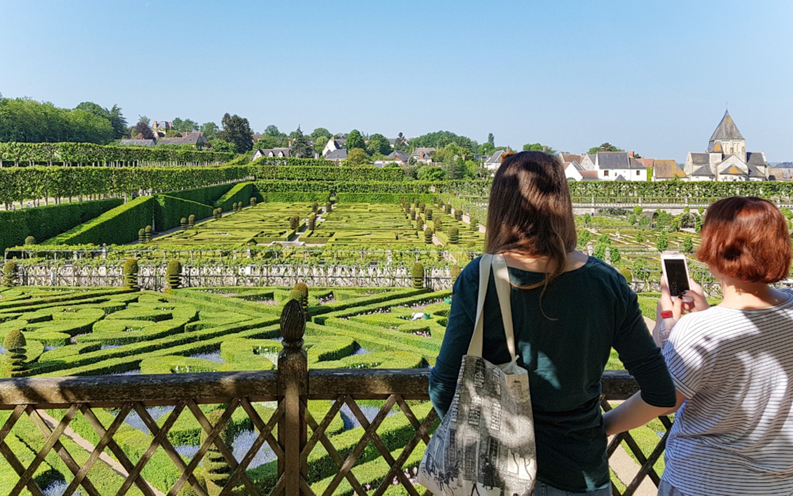 Visitors overlooking the intricate hedges of Chateau de Villandry gardens in France.