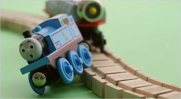 toy locomotive falling off the tracks