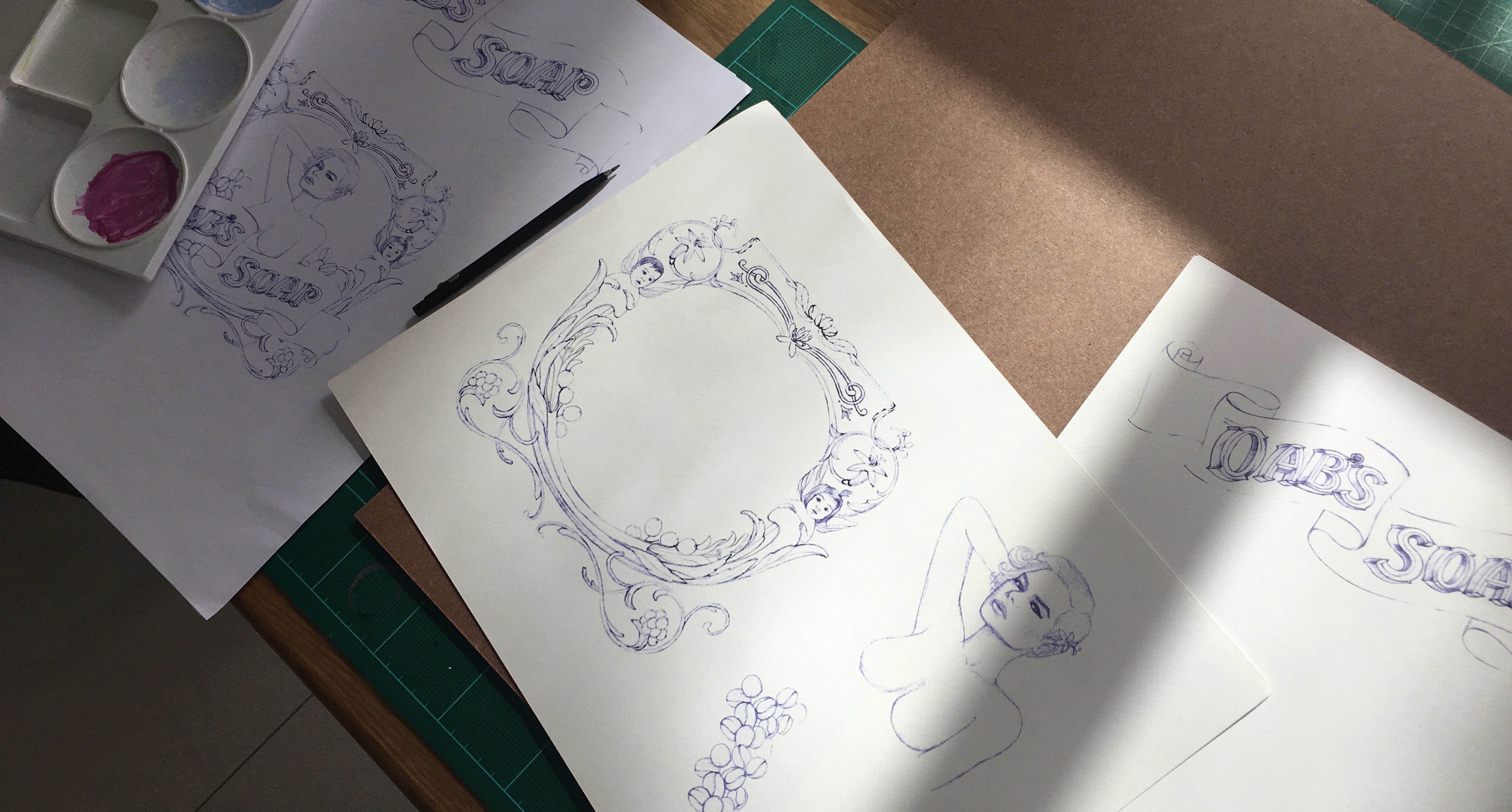 A photo of some print designs drawings on paper depicting frames or woman figures.