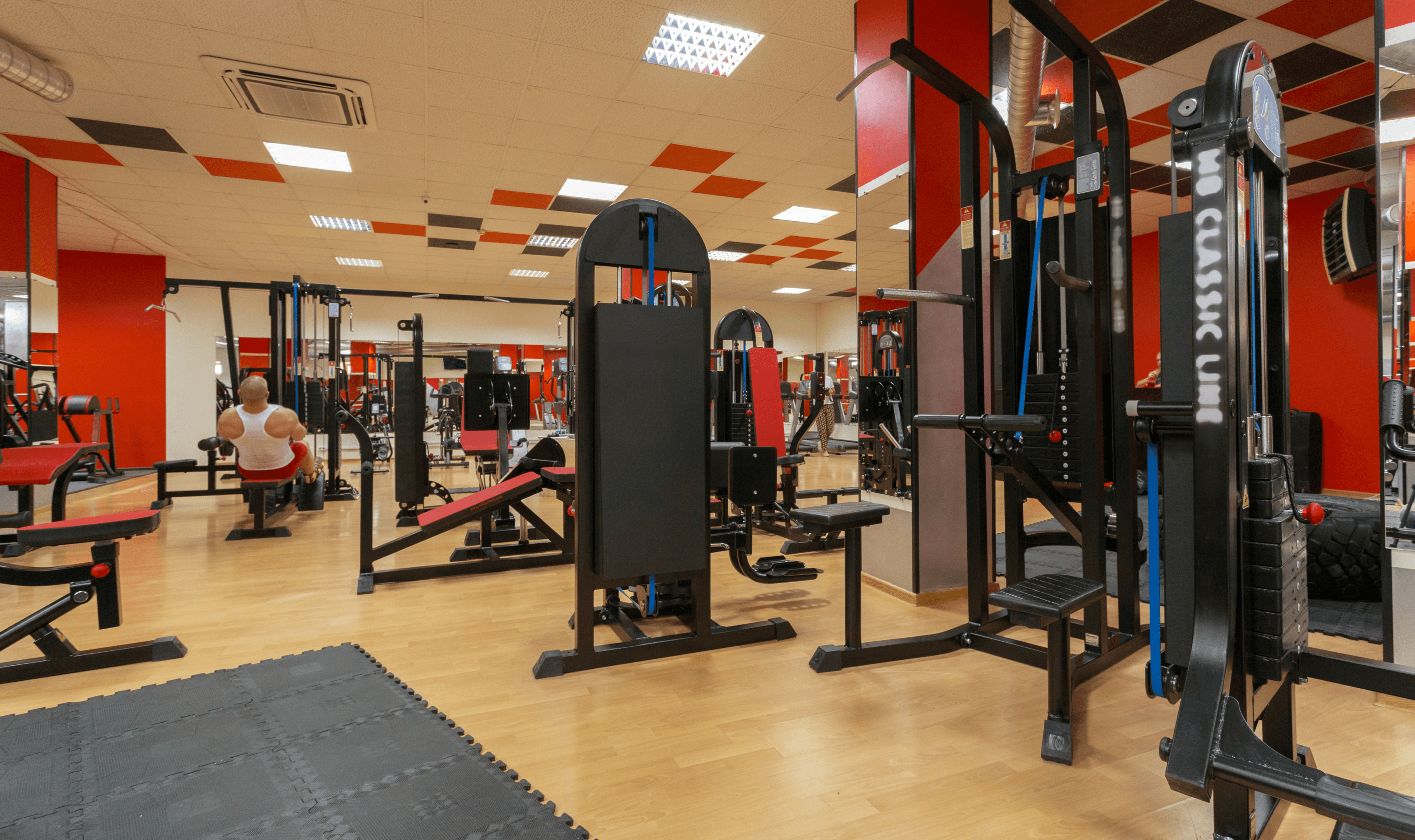 Modern gym with various exercise machines.