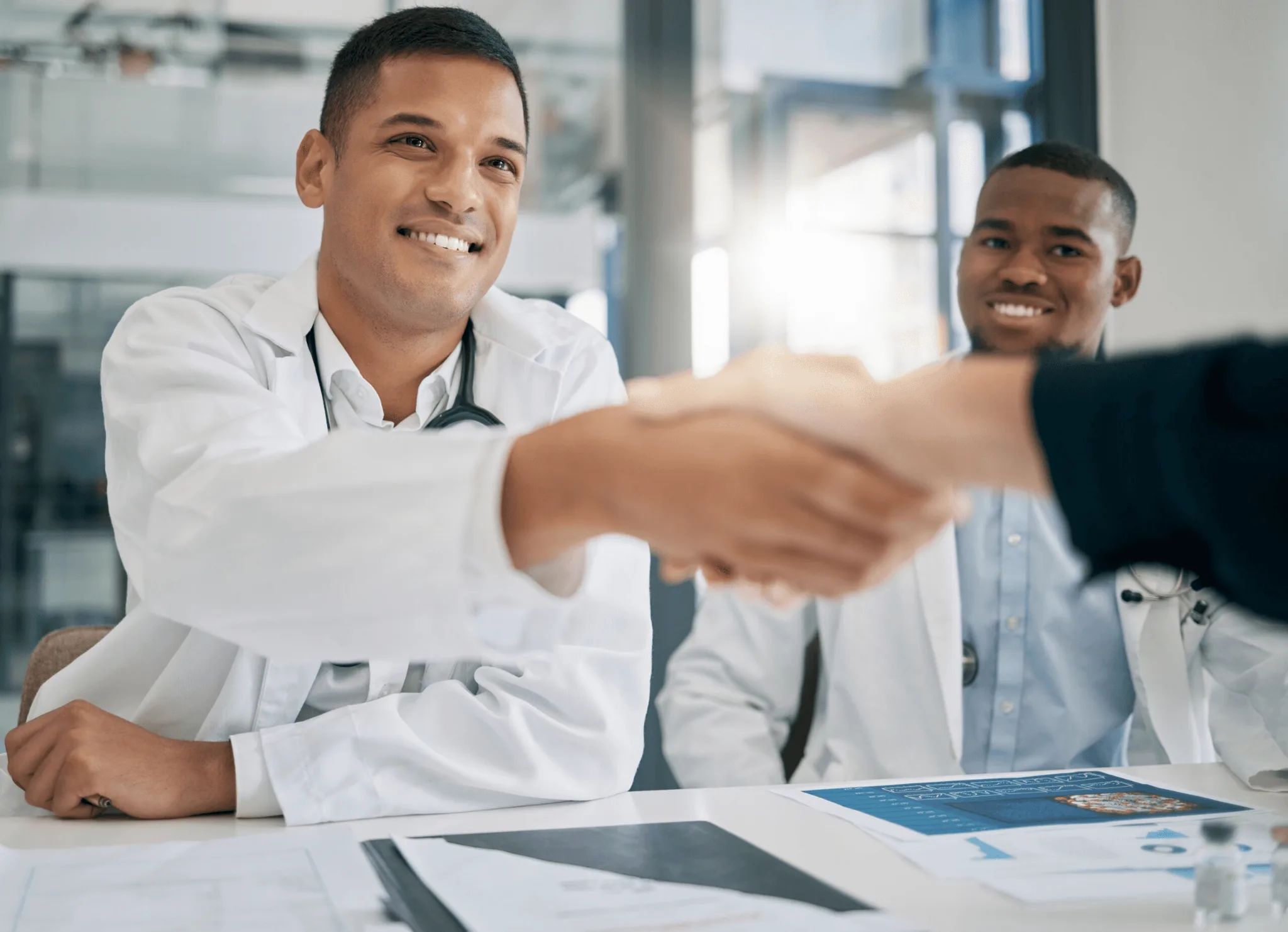 Doctor shaking hands with someone out of frame.