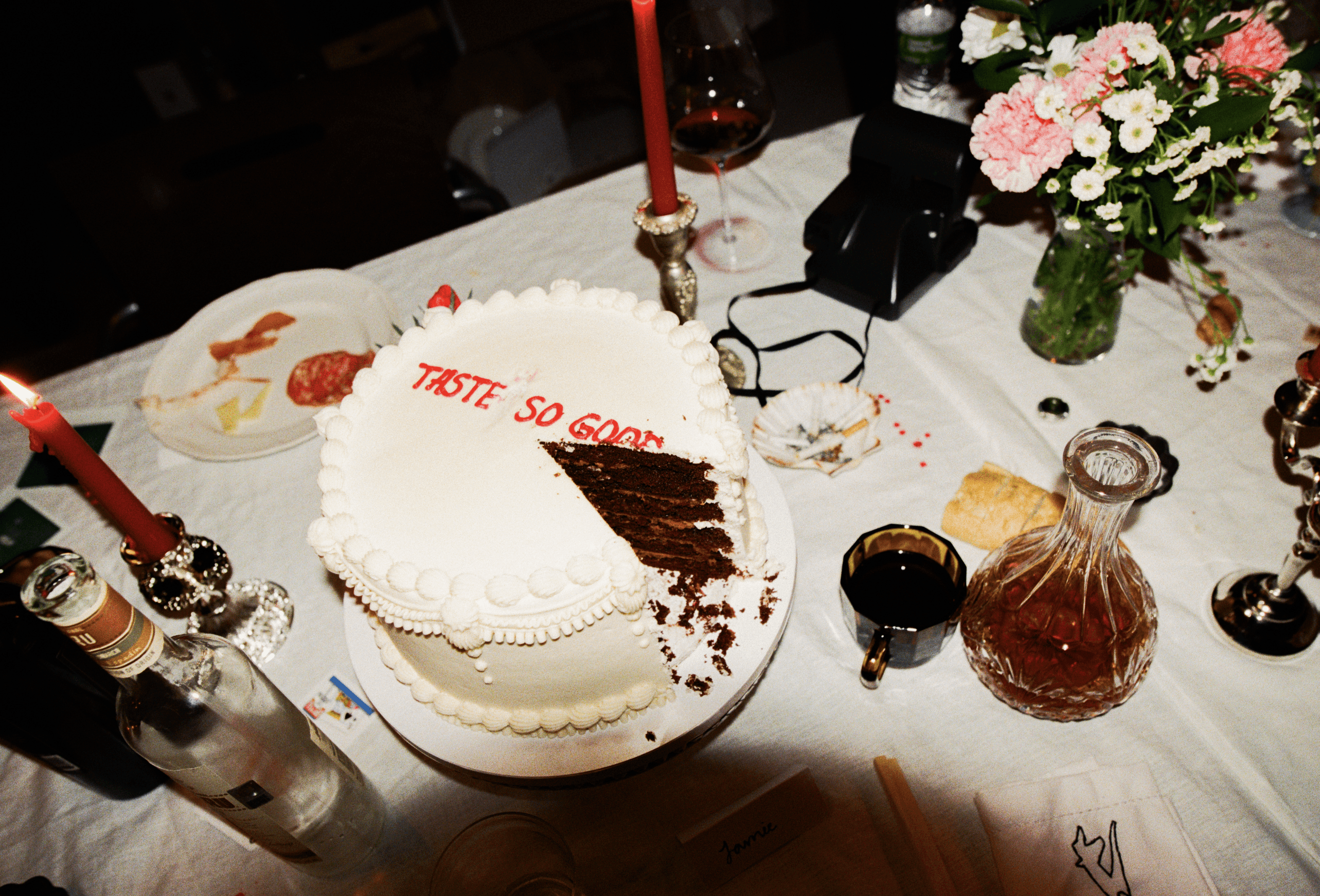 A decorative floral arrangement spills over a table draped in red fabric, creating an elegant atmosphere.