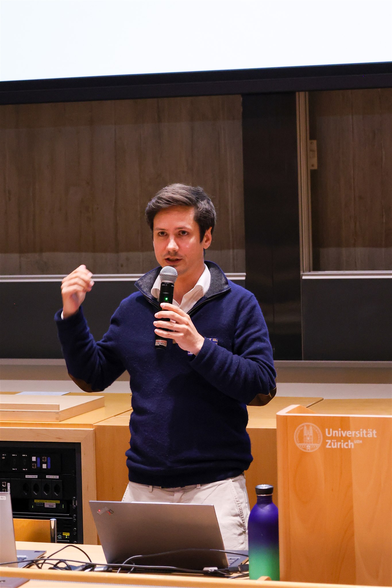 Mizuri event coverage showing speaker explaining ideas at University of Zurich
