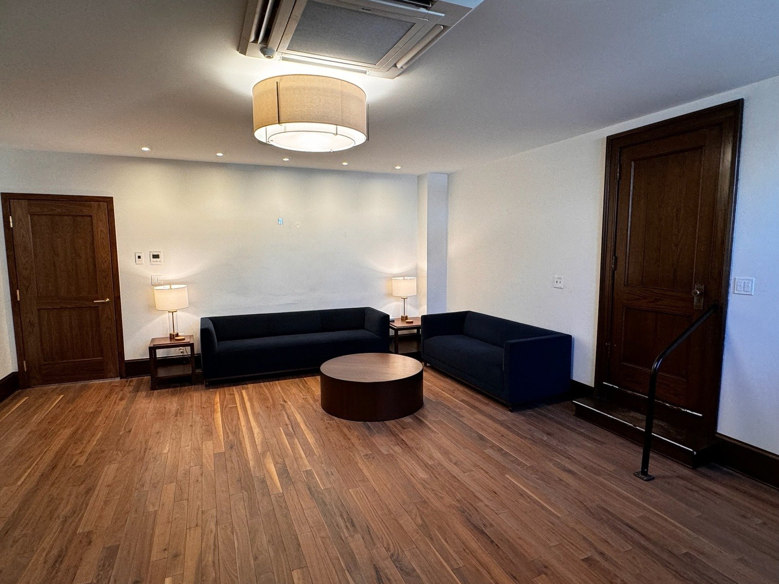 Library at Grace Trinity Church with two navy blue sofas, a round wooden coffee table, and soft lighting, creating a cozy seating area.