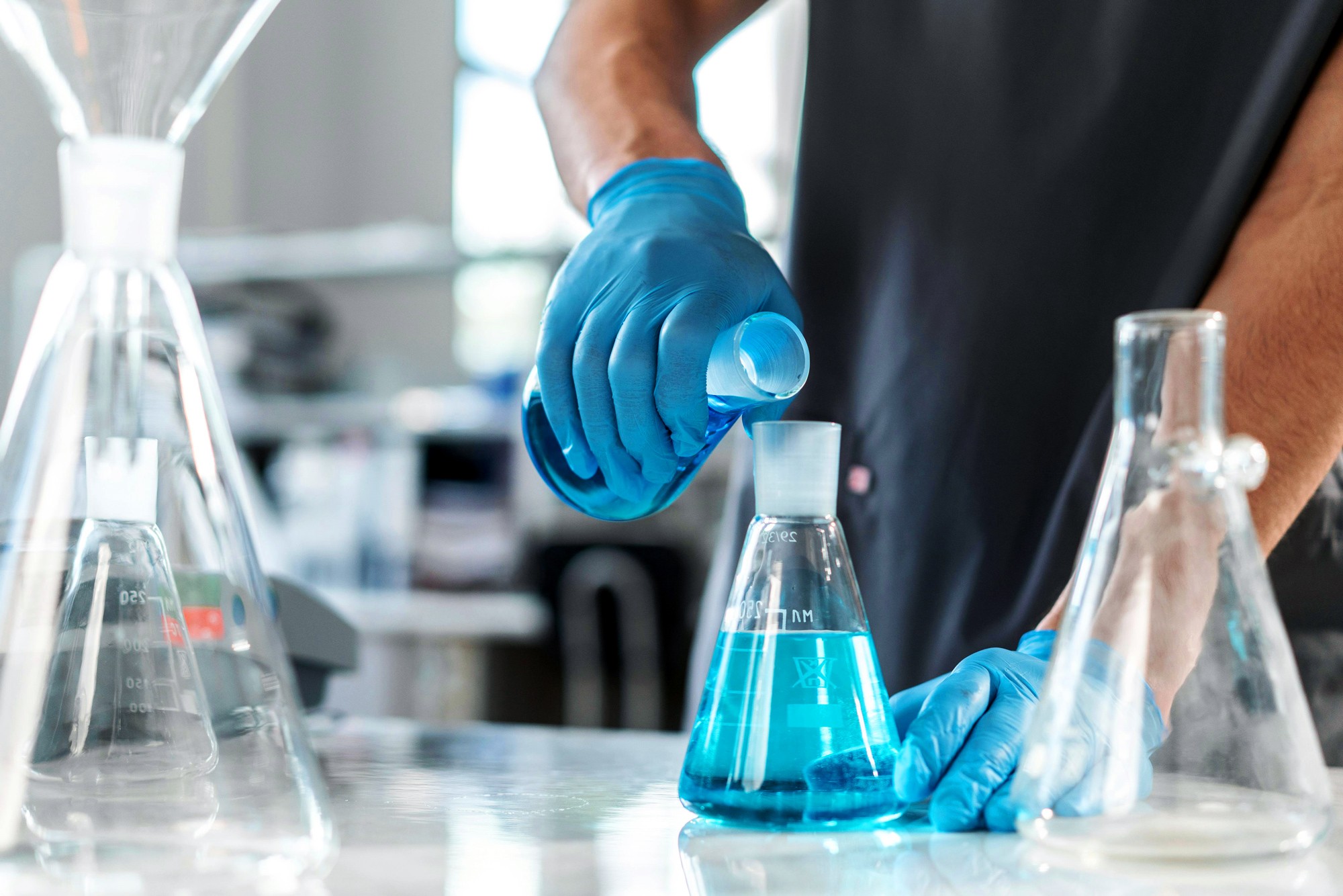 Chemist pouring liquid into a beaker at Stellar Chemical