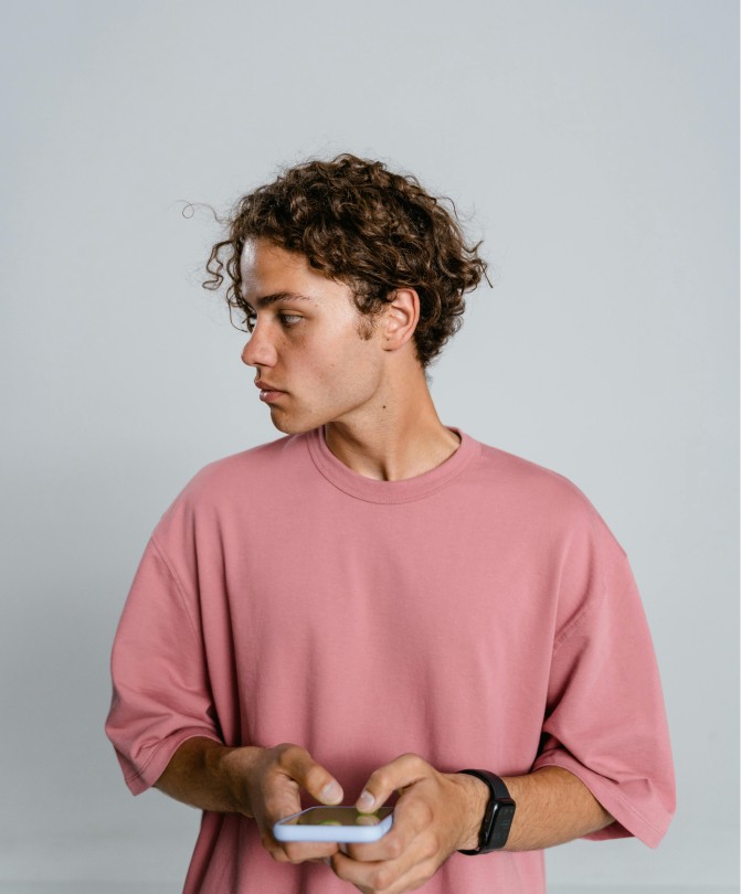 Portrait of a person in a pink sweater against a light background