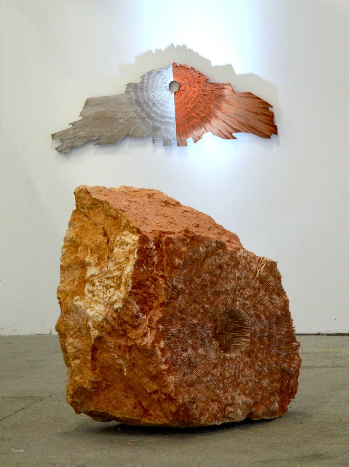 Opera di arte Tempo Astratto iStone Arte installata in showroom aziendale durante evento inaugurale, sculture radiali illuminate e pubblico in interazione con le opere