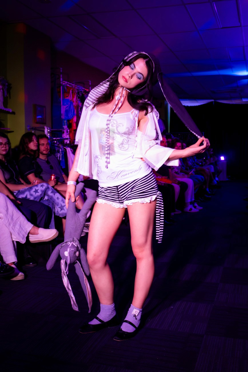 female model on runway wearing bunny ears and holding a toy bunny