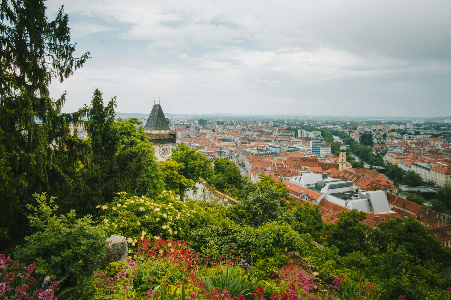 Image of Graz city from on top of the hill. Clock tower and orange rooftops.