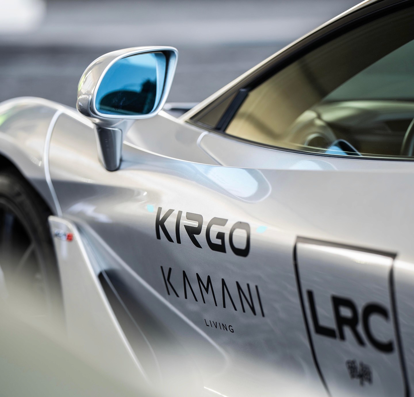 Black-and-white party photo of a smiling man in a check blazer among a crowd.
