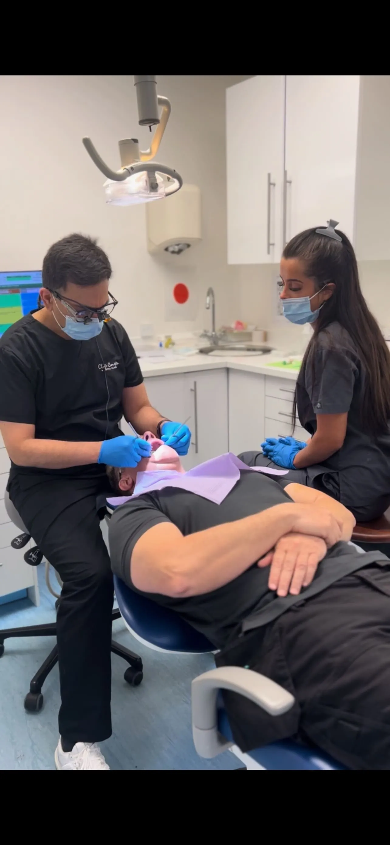 Dr Khalid and Sophie, in surgery, giving treatment to a patient