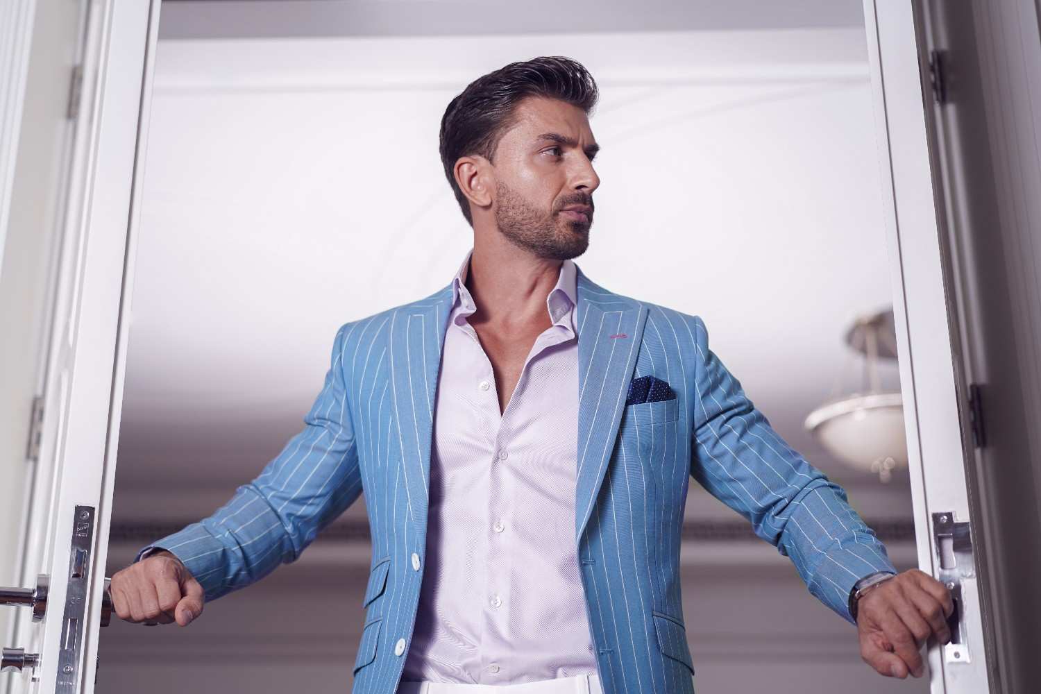 A Person in Dubai entering a room in Bespoke Suit