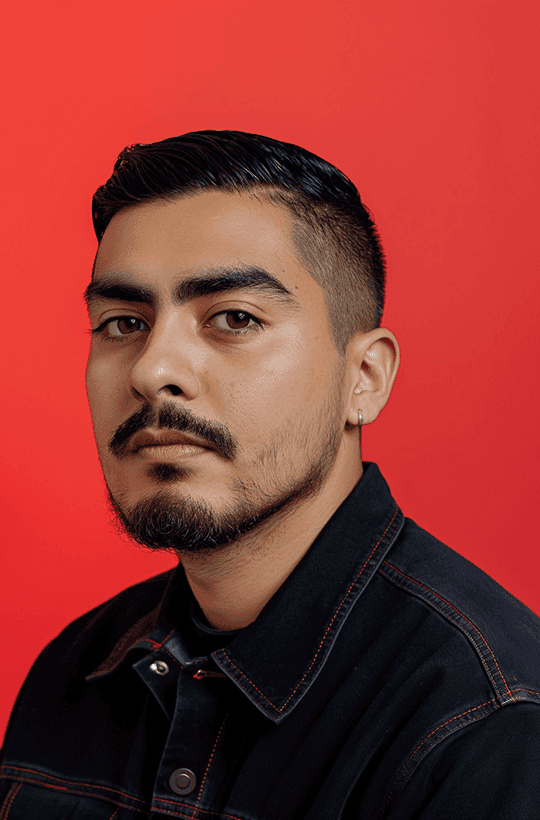 A man with a beard wearing a black shirt, looking directly at the camera with a neutral expression.