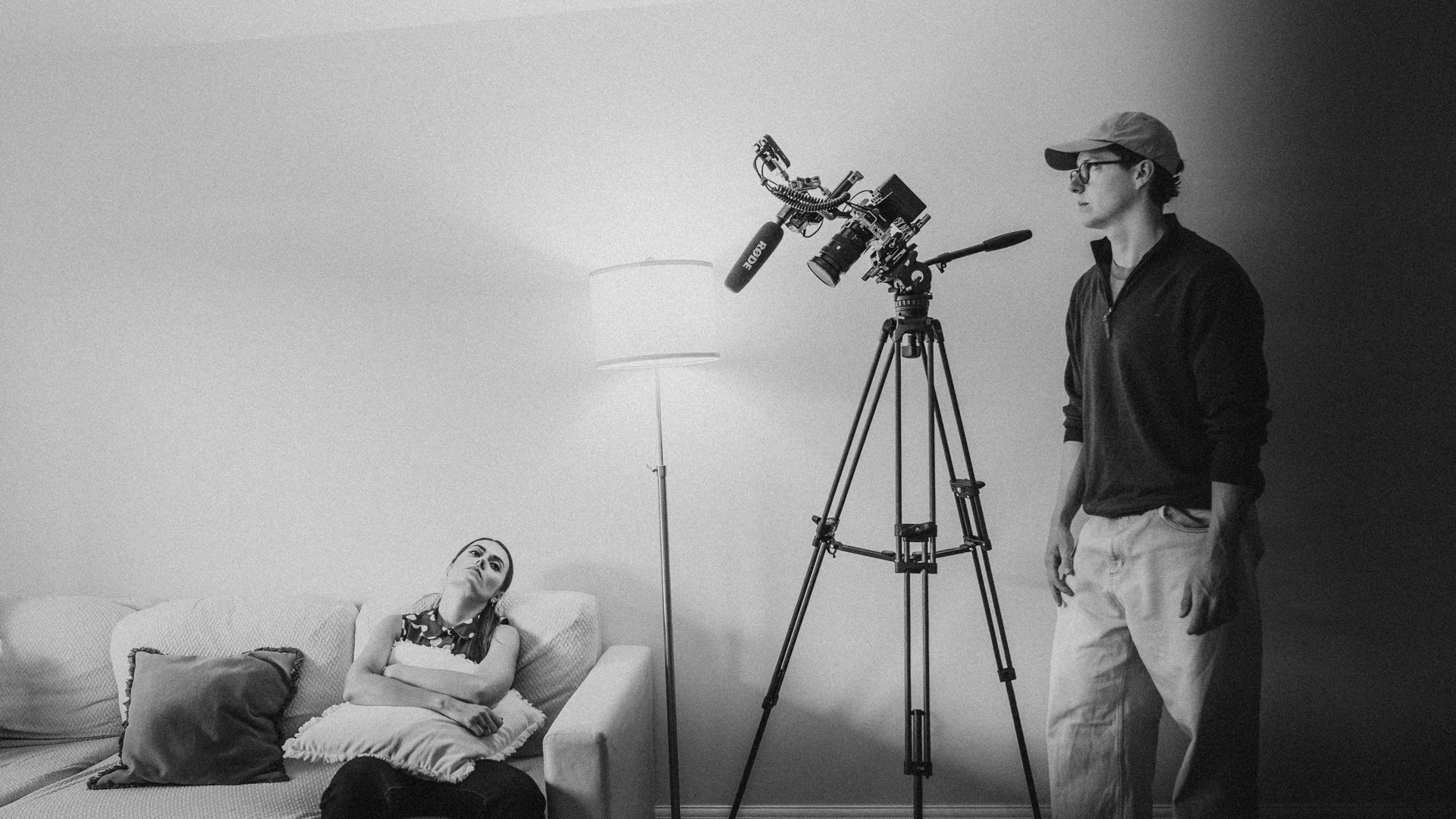 Behind the scenes of a Max Baker Media film production, with filmmaker Max Baker beside a cinema camera and microphone setup during an indoor shoot.