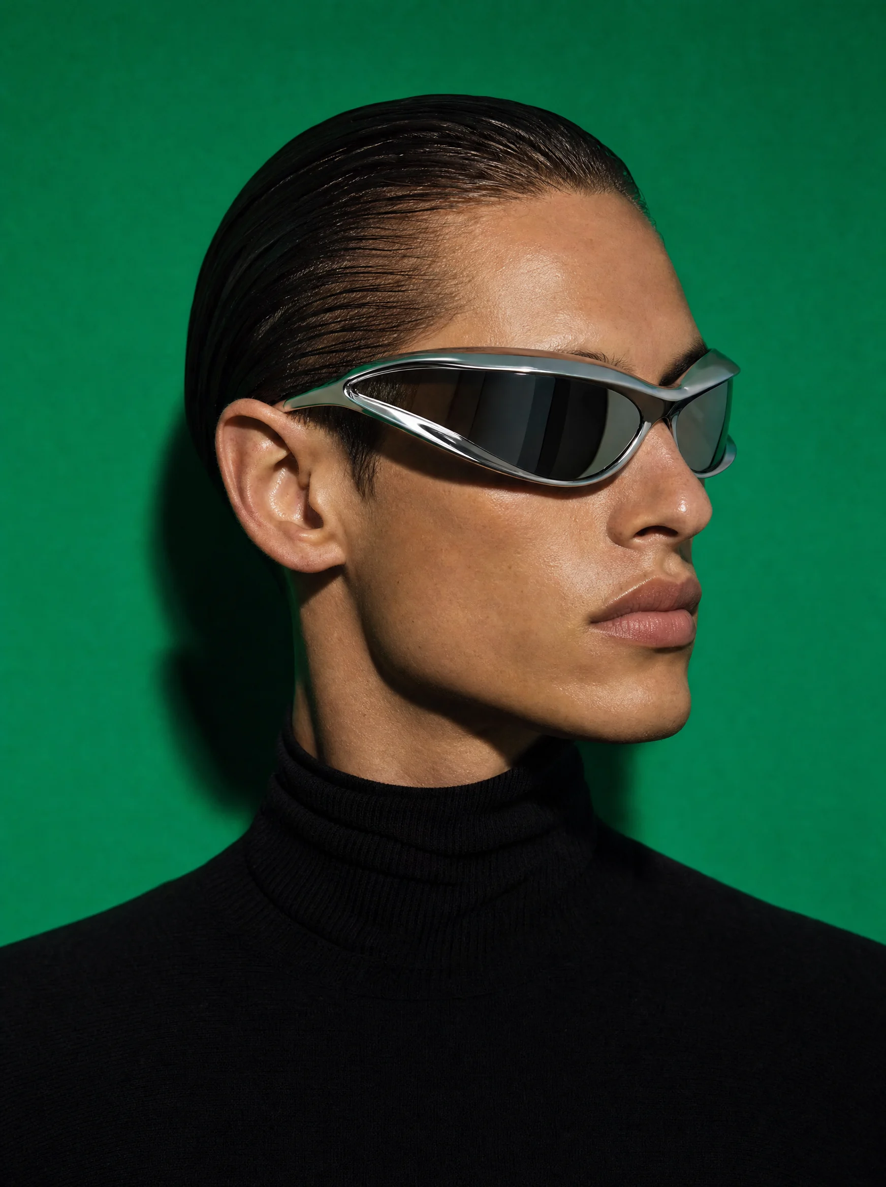 Man in chrome wraparound sunglasses against a green wall, Ferro eyewear campaign