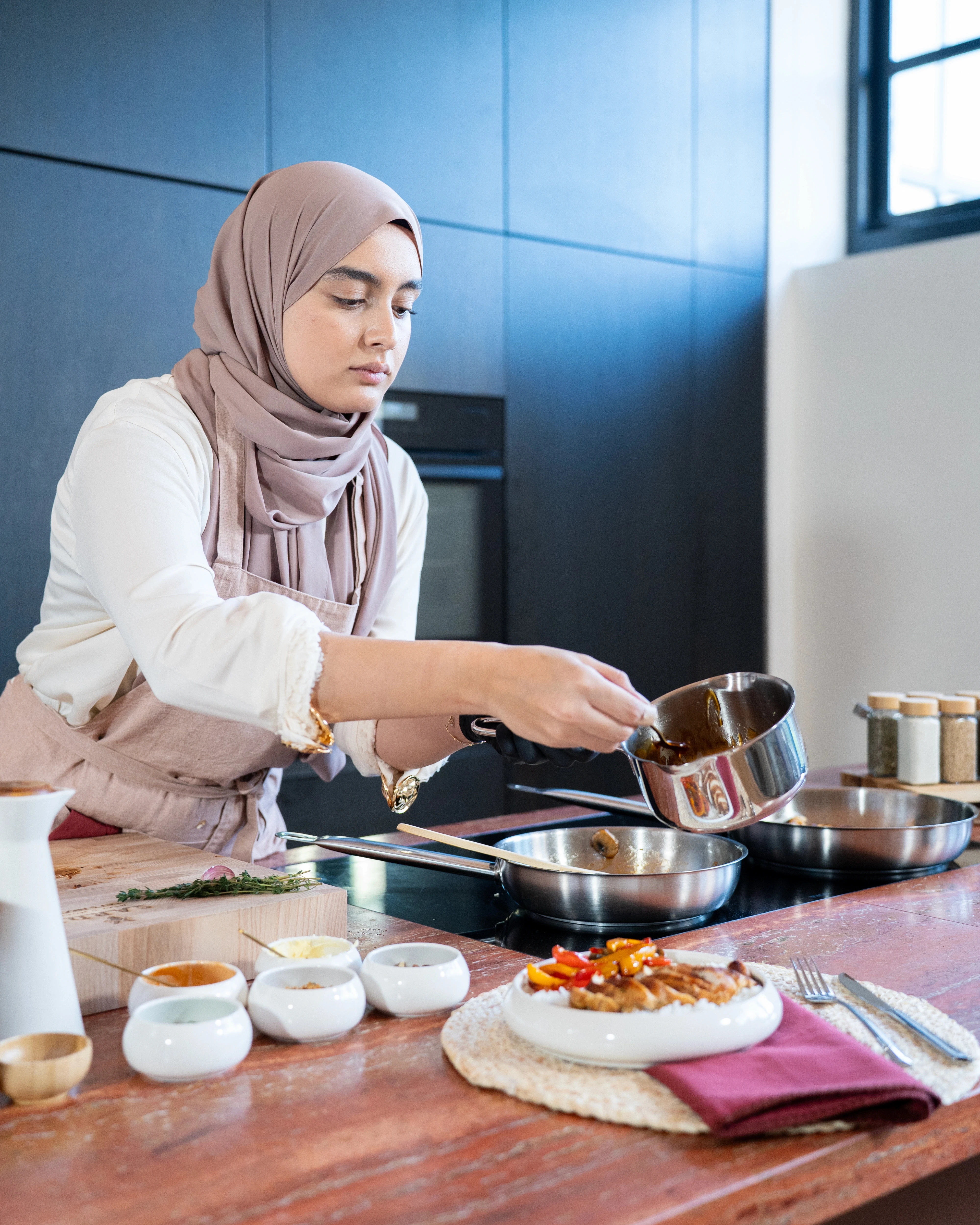 Bottled OYM olive oil on a table with bread and fresh olives as sidedishes