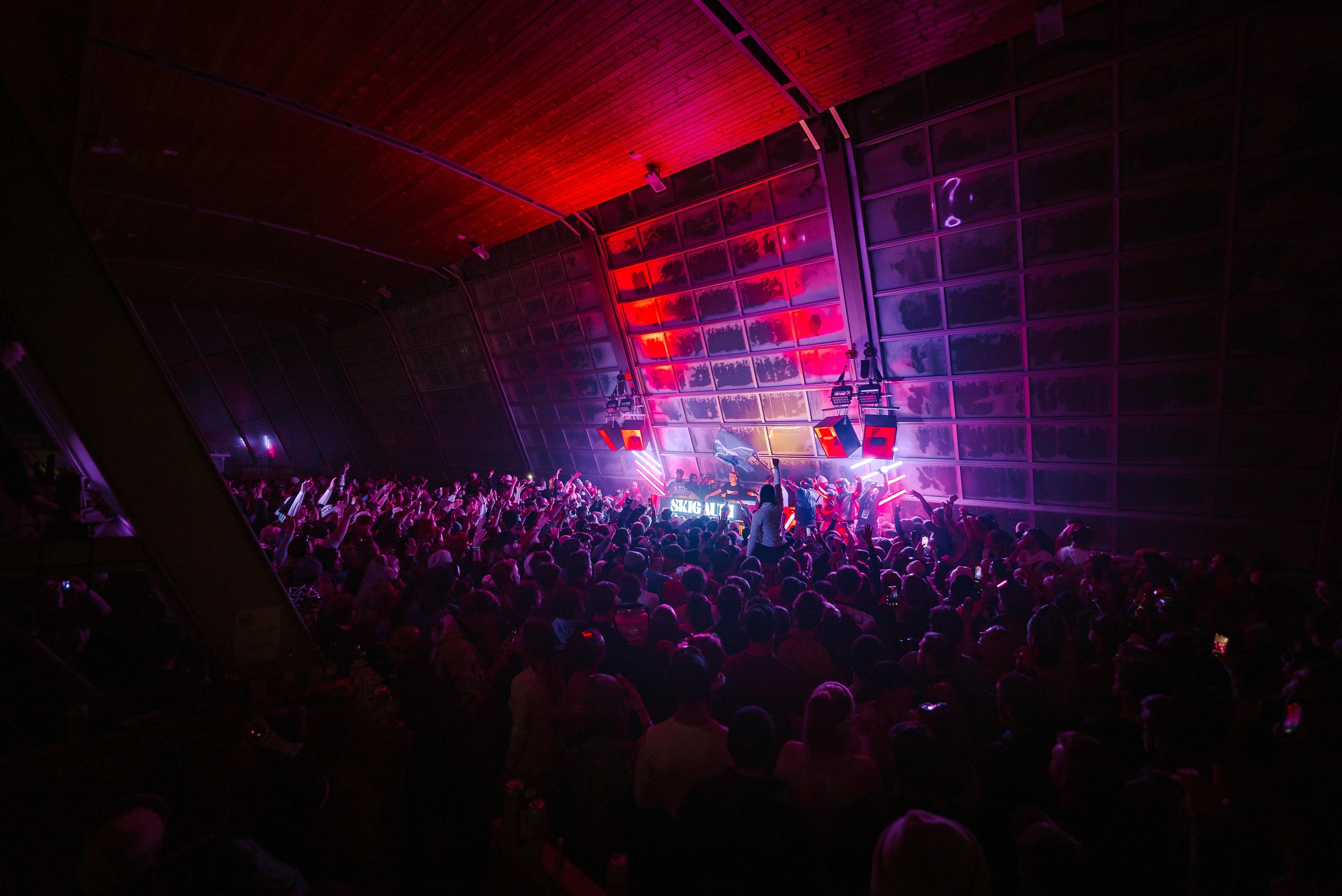 Vibrant stage lights with purple and pink hues illuminating theater ceiling.