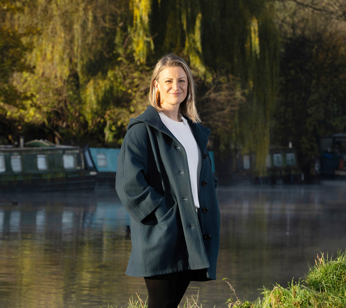 Ruth Fenton, a licensed acupuncturist, smiling in a natural outdoor setting by the River Lea.