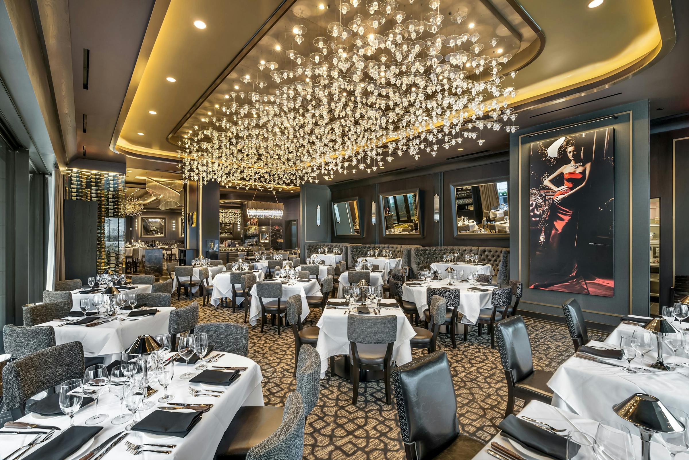 Main dining room at Mastro's Steakhouse Columbus with white-clothed tables under a glittering light fixture