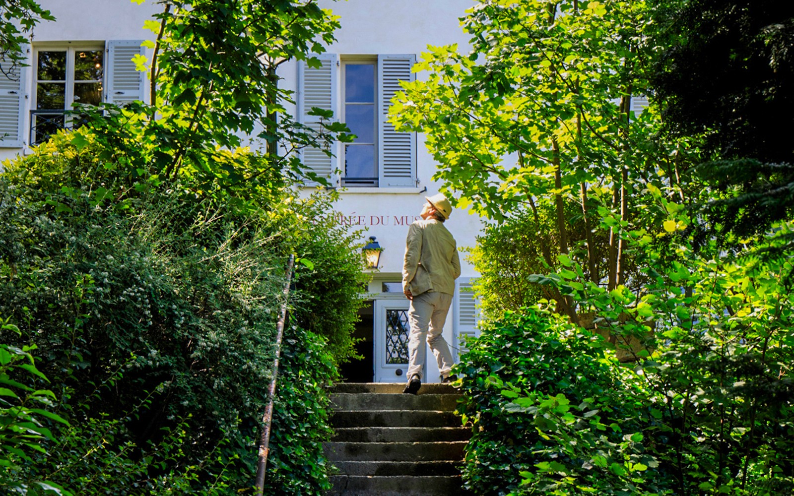 游客正接近被绿植环绕的蒙马特博物馆入口。