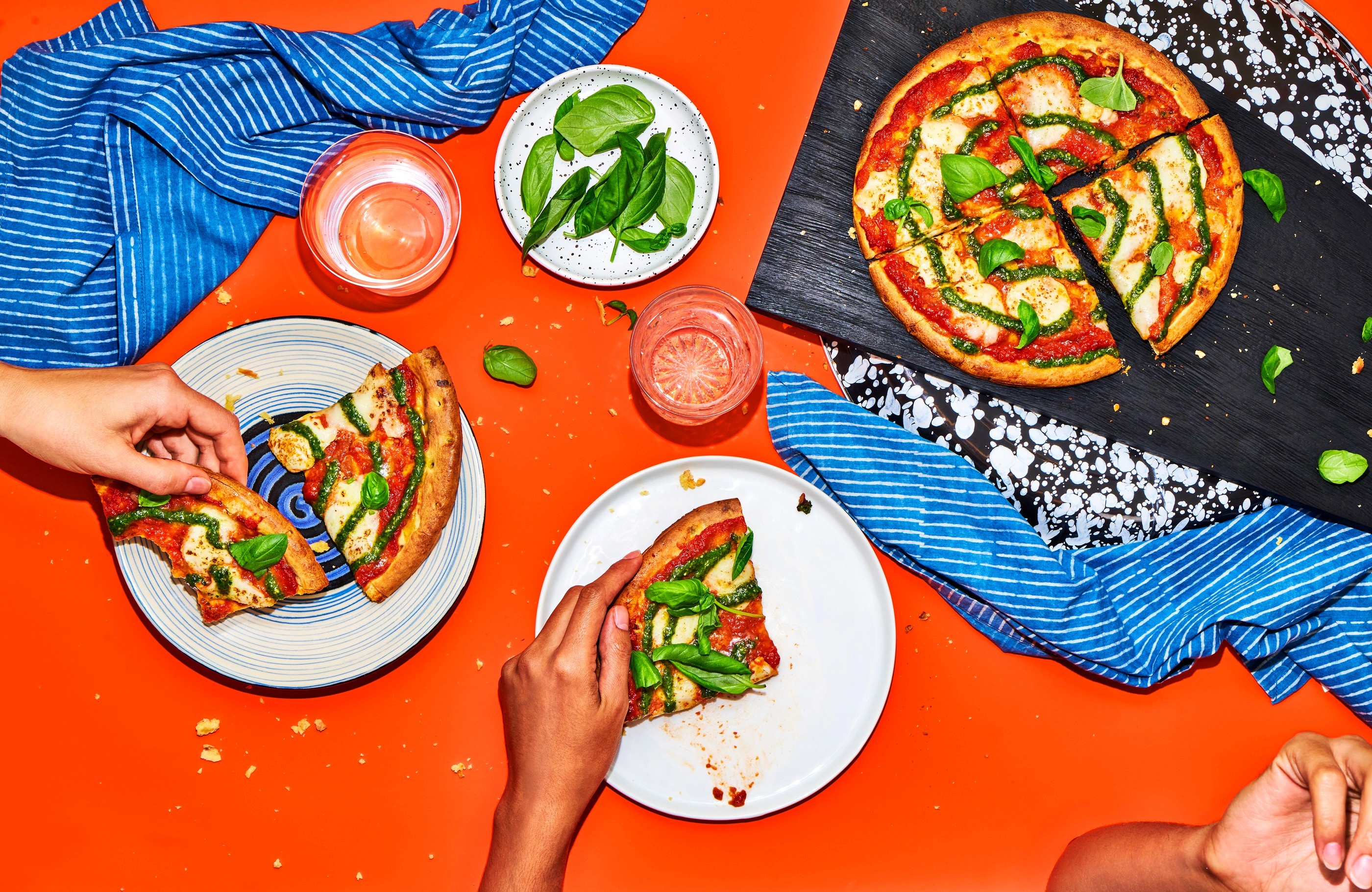 Sharing pizza, orange tabletop