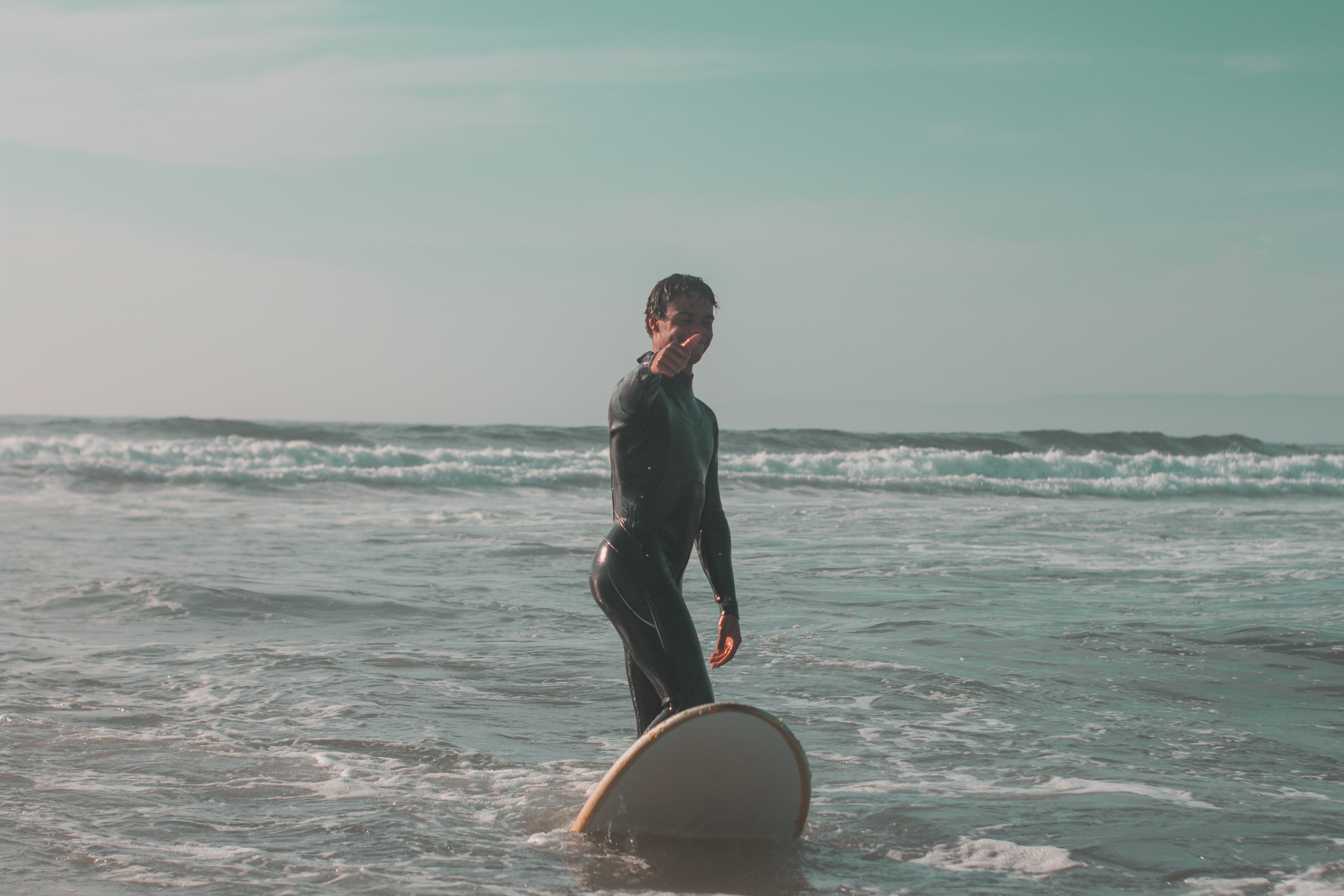 a group of people carrying surfboards on top of a beach