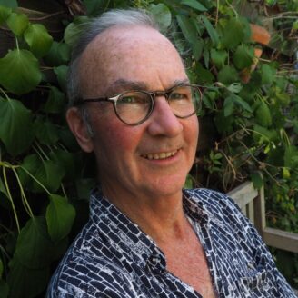 A person smiling in a garden scene.