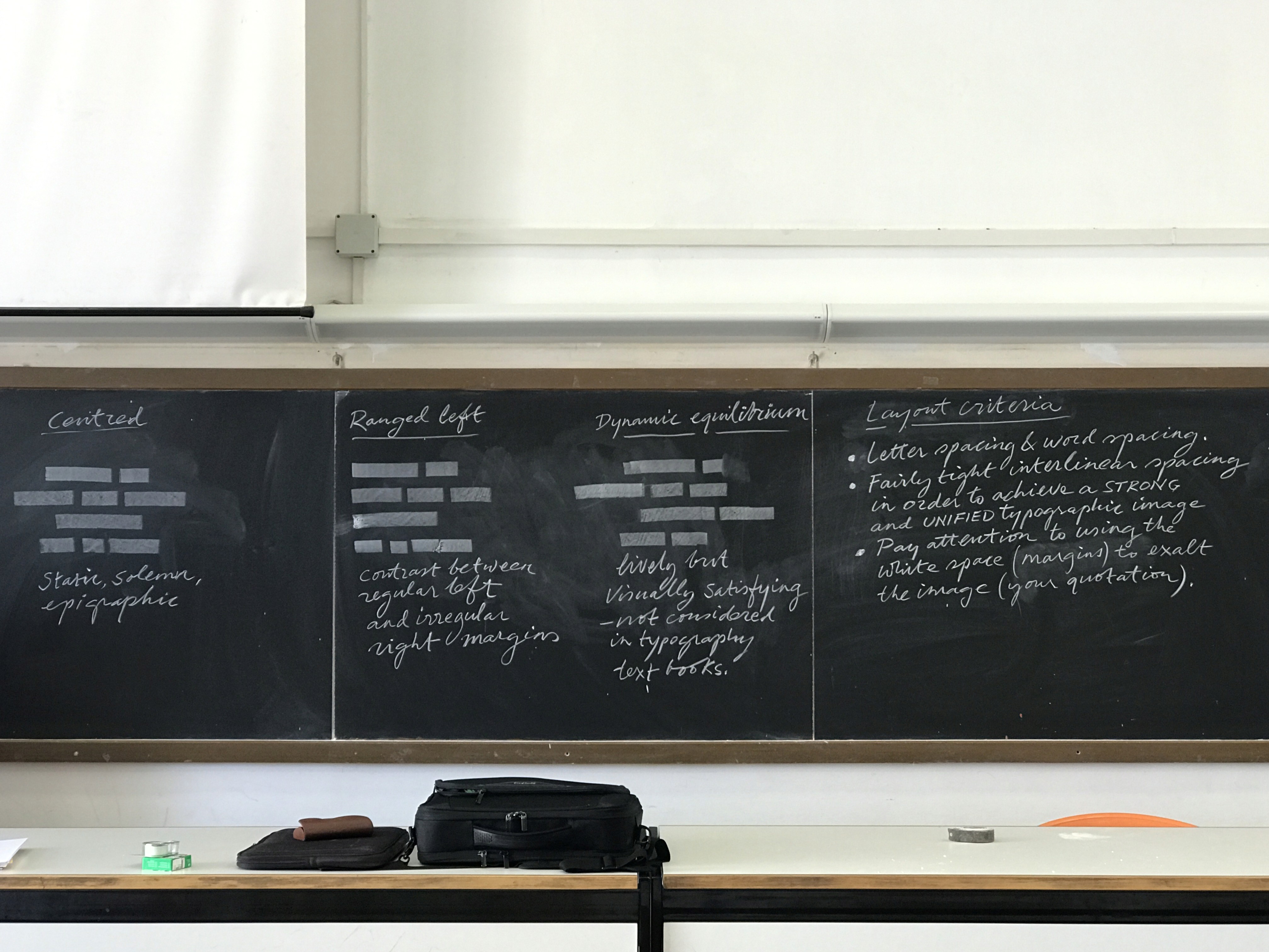 A class blackboard that has some writing on it and a bench with a backpack on it.